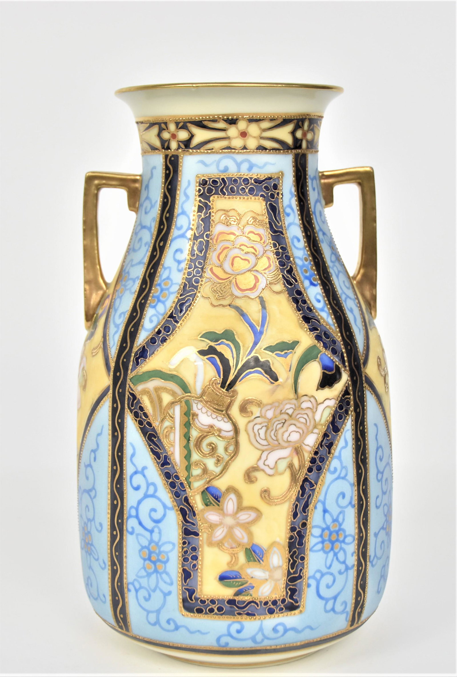 Nippon Ornate & Colorful Handled Vase: With stylized floral. Raised gold. 8 1/4” T. 4 3/4”D. Very good condition. Green mark.