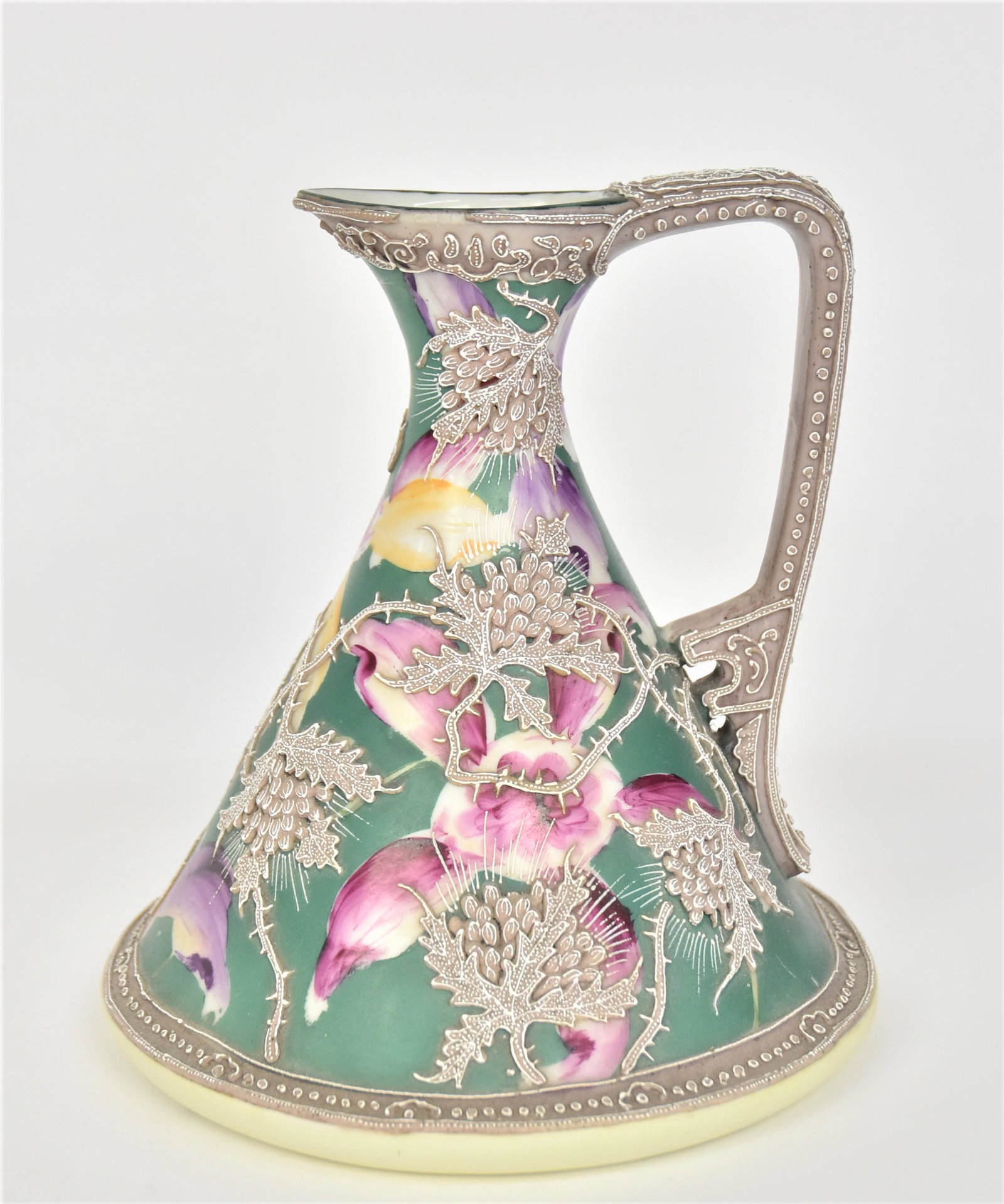 Nippon Moriage Petticoat Ewer: With orchids nicely overlaid With meandering stems of Moriage teasel flowers. Decorative pierced handle. 7 3/4”T. 7 1/4” across base. Minor Moriage missing at rim & bead on handle. Otherwi