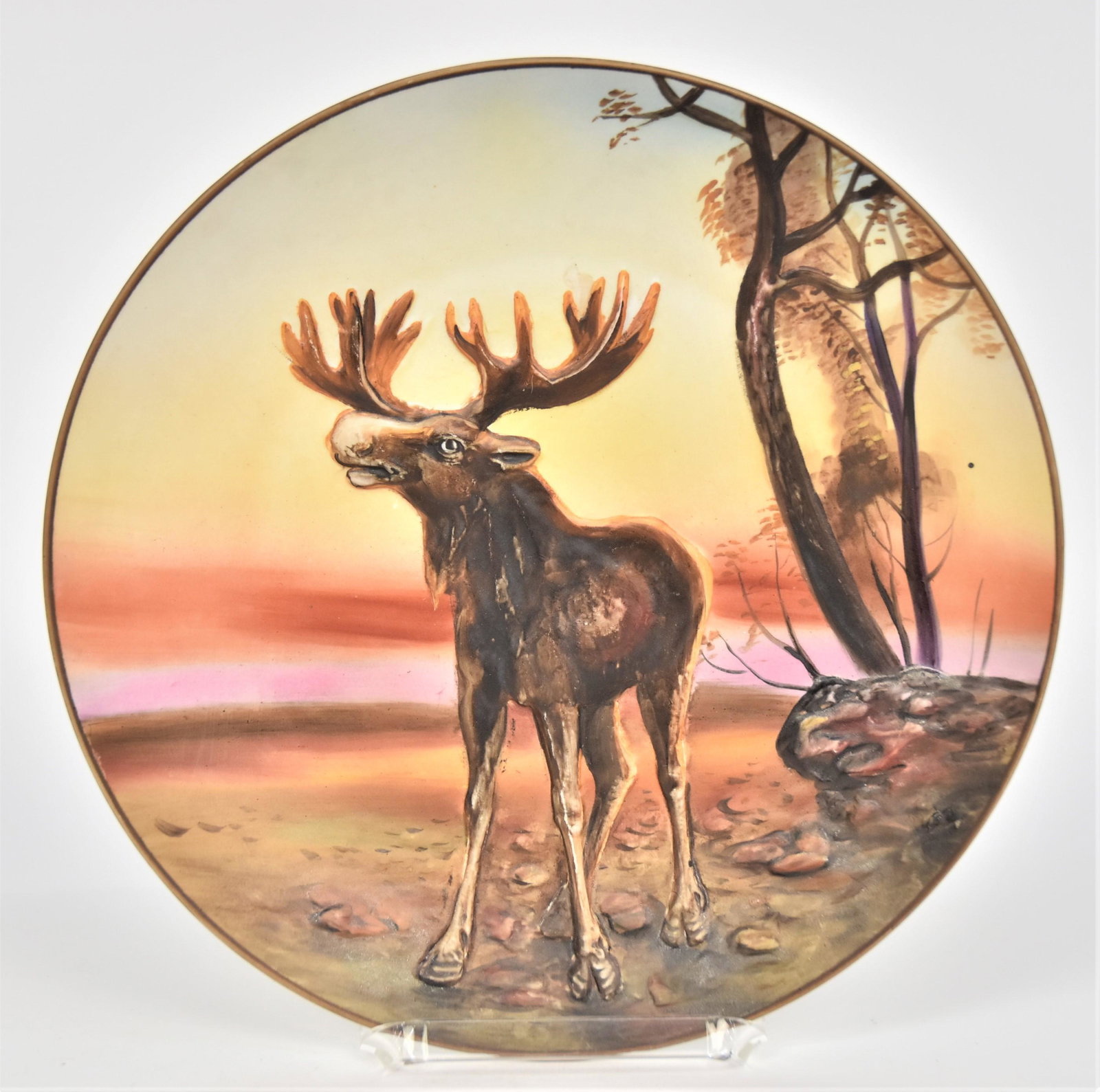 Nippon Molded in Relief Scenic Plaue: With a bellowing moose. 10 1/2”D. Colorful. Very good condition. Green mark.