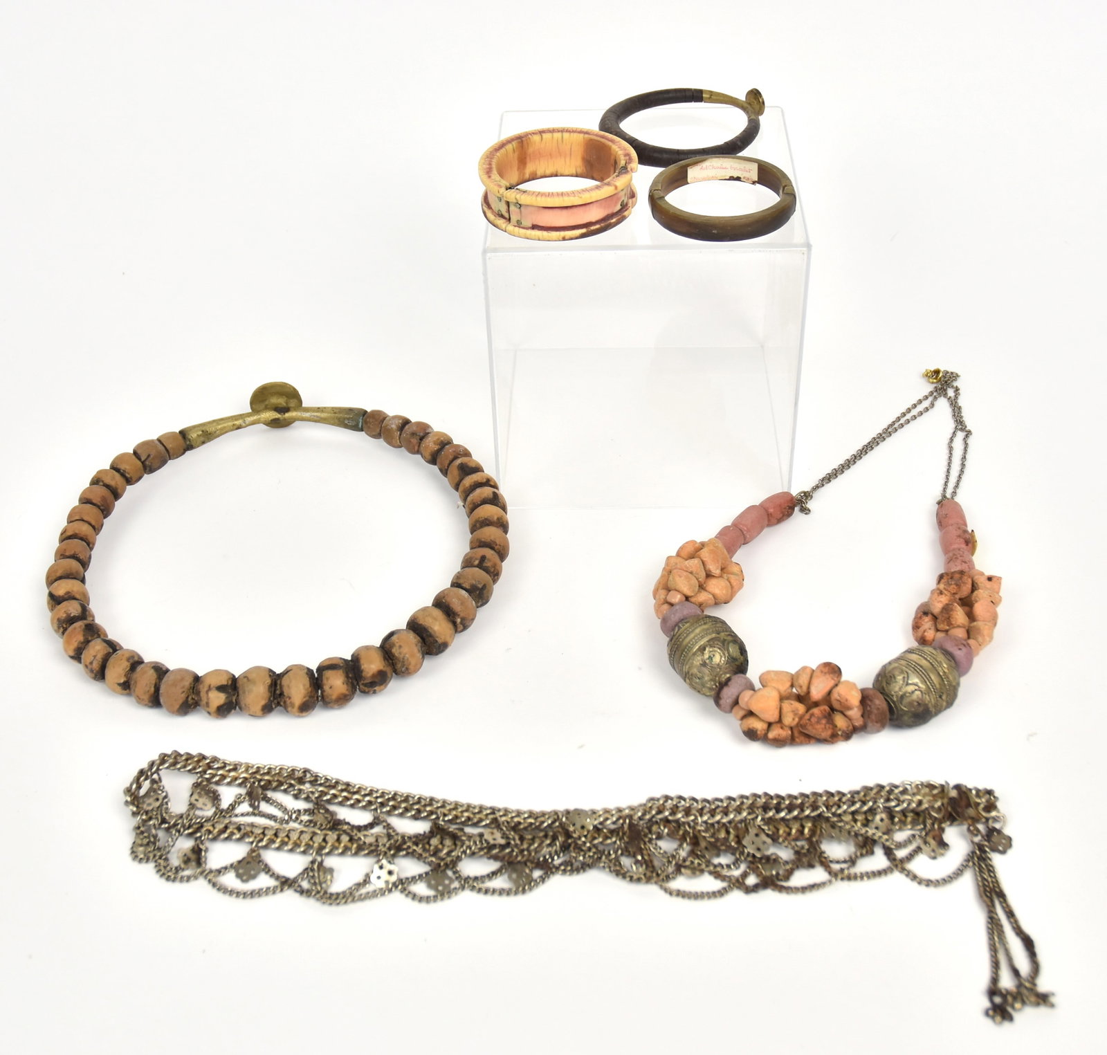 African Necklaces, Belt & Bracelets: Lot of six, including three bracelets; one in horn with brass hing and clasp 2 ¾” diameter; plus brass and tapered leather washer example, 3 ¼” diameter; plus bone example wi
