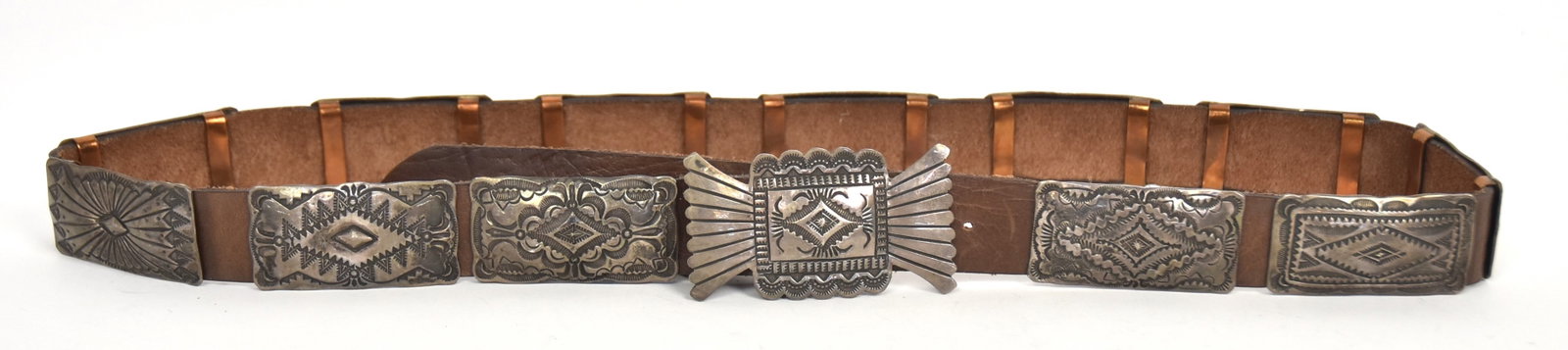 Navajo Silver Concho Belt: Artist initialed VJP/Sterling with 12 different tooled sterling rectangular conchos and larger buckle, signed on brown leather belt, 38 1/2" long. Condition Fine.
