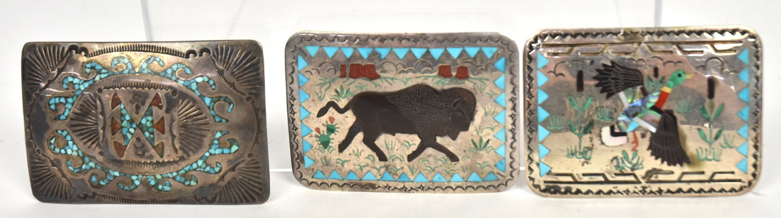 Three Signed Sterling Navajo & Zuni Belt Buckles: All with turquoise and other stone inlay, one with Bison, one with mallard duck, both signed S&B Sterling Zuni, 2 3/4 x 2"; and one with geometric designs, 3 x 2", marked T Sterling, total weight ??> 