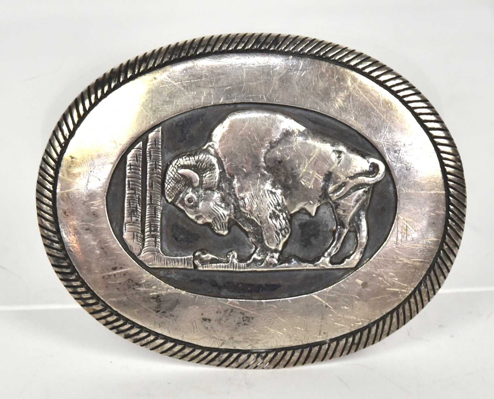 Tom Game Sterling Navajo Belt Buckle: Oval with low relief bison facing left with gadrooned edge, signed Tome Game, Sterling, 3 1/8 x 2 3/8", weight ??. Condition Fine.