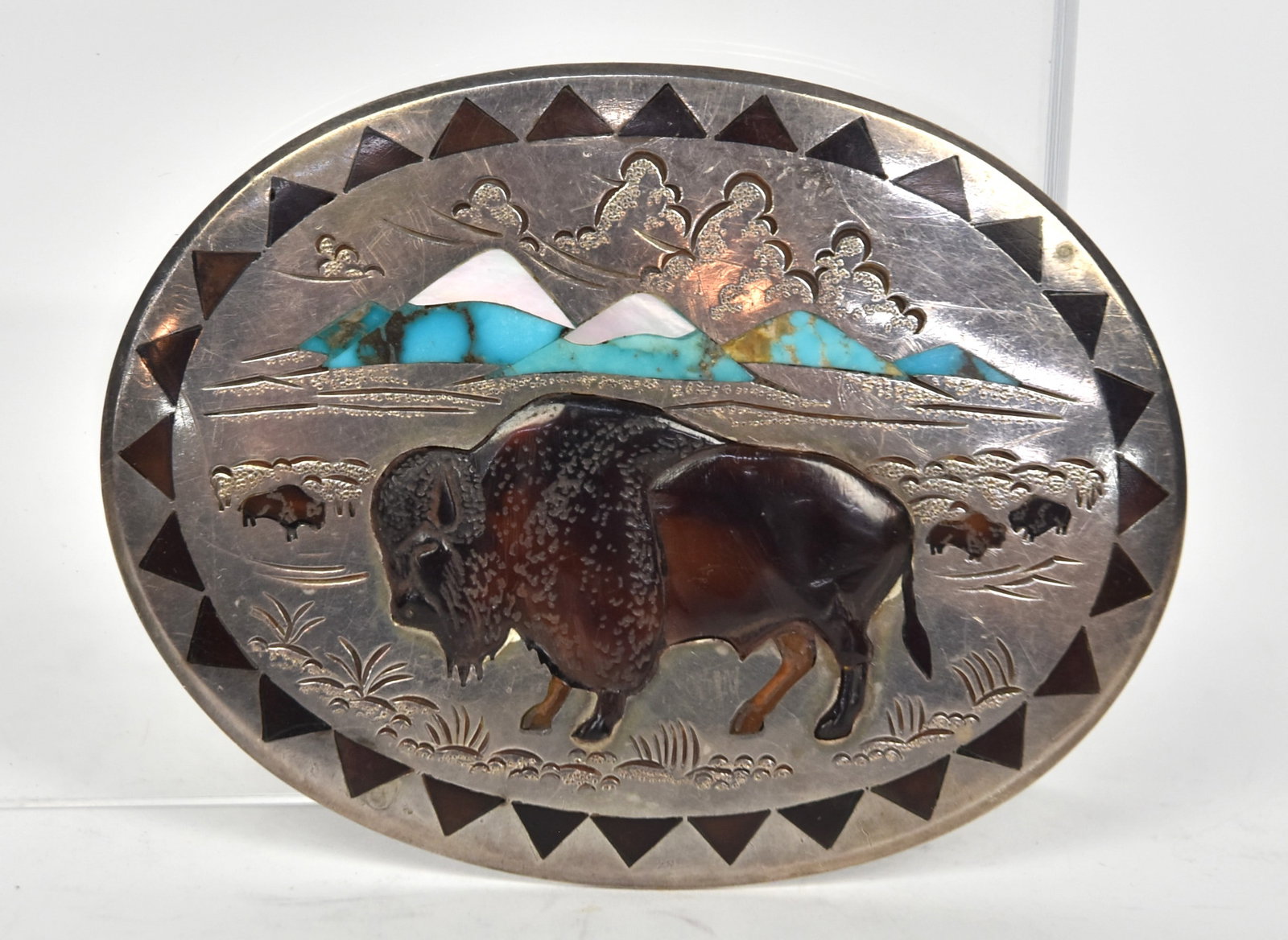 H&L Barber Sterling Zuni Belt Buckle: Oval signed on back Henry & Linda Barber Sterling with carved and inlaid relief bison in horn with mountains in background inlaid with turquoise and MOP, engraved details, 3 1/2 x 2 5/8", weight ??. C
