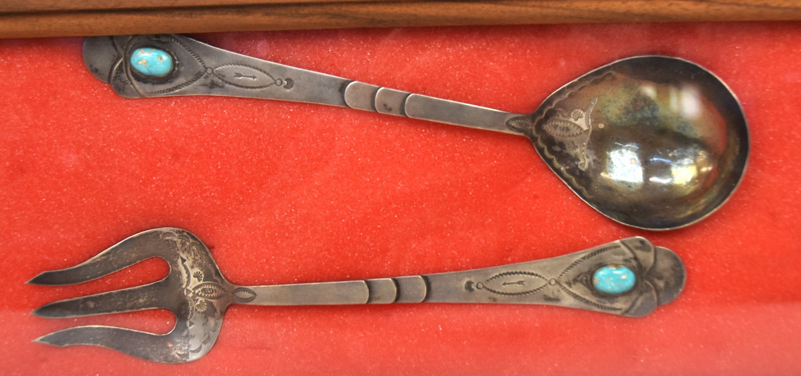 Navajo Coin Silver Salad Set: Circa 1910-30 hand tooled with geometric motifs and inset with turquoises stone, each marked with fire bird and Hand Made/By Indians, above and Solid Silver below, 10 1/4" long, weight ??. Condition F