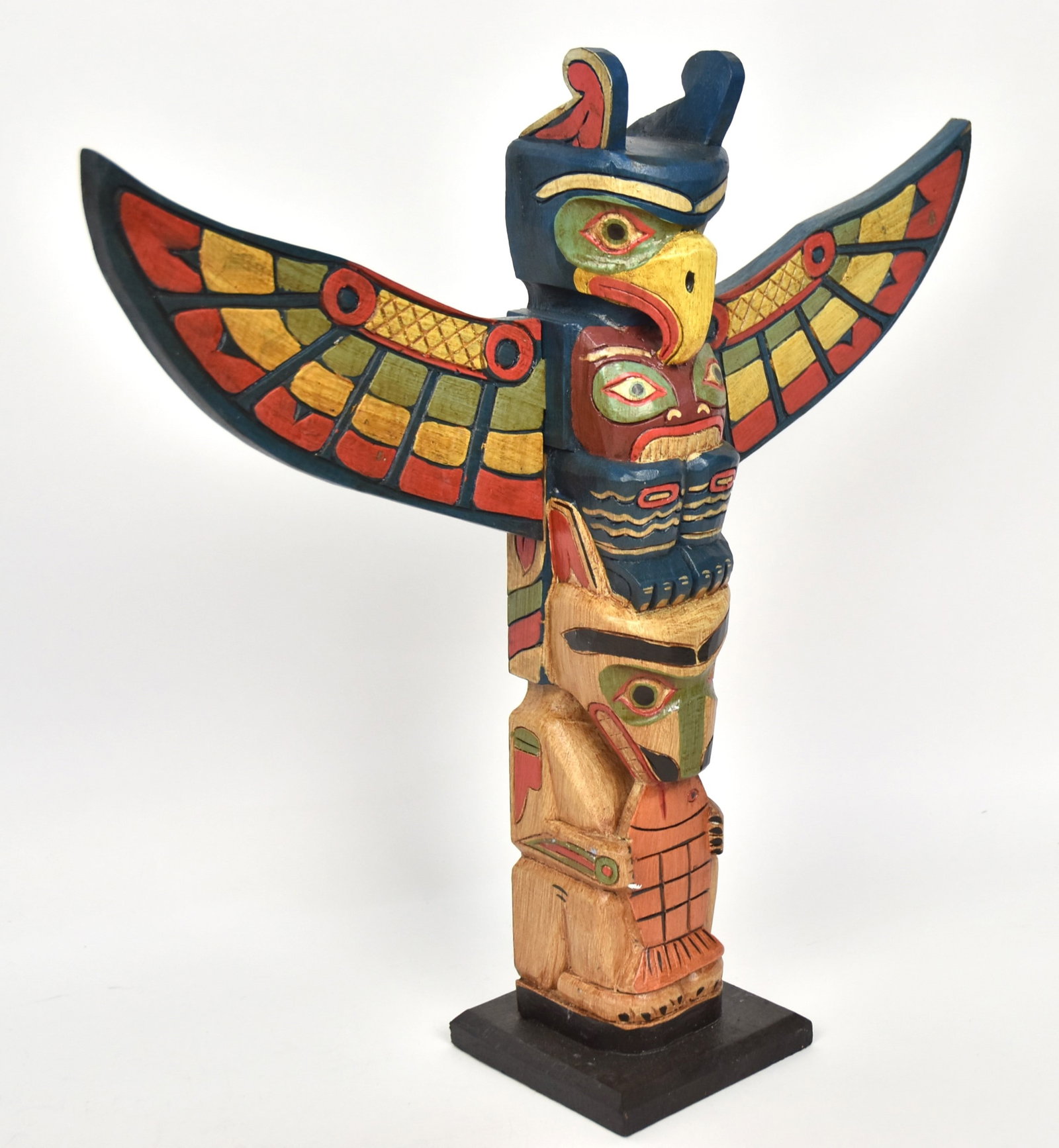 Northwest Coast Totem Pole: Carved wood in original polychrome painted finish with bear eating fish at base and eagle at top, winged are mortised in and removable, 5 1/2 x 21 x 19 1/2" high. Condition VG+.