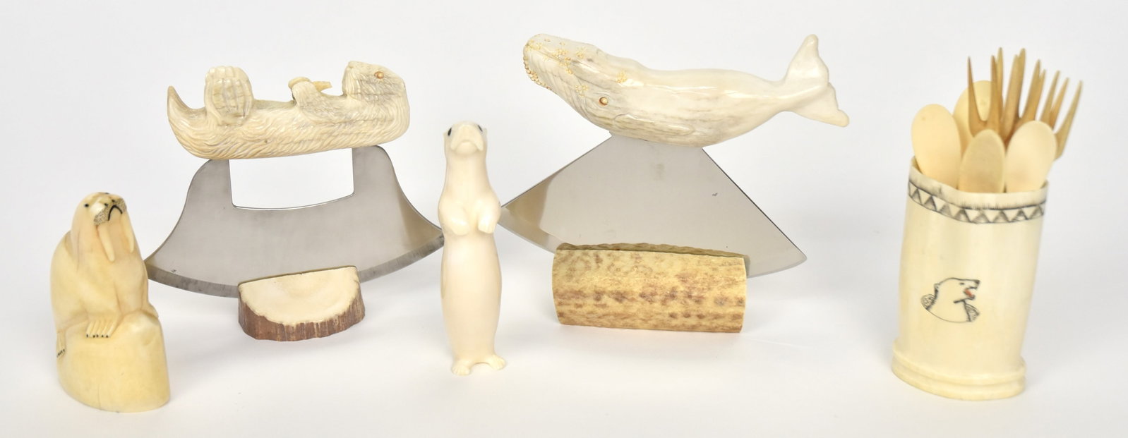 Inuit Carvings: Lot of 14, including two ulu knives, one with carved whale handle and one with carved otter handle, each with antler mount, 5 1/2" wide x 5 1/2" high in mount and 5 1/2" wide x 5 high in mount; plus s