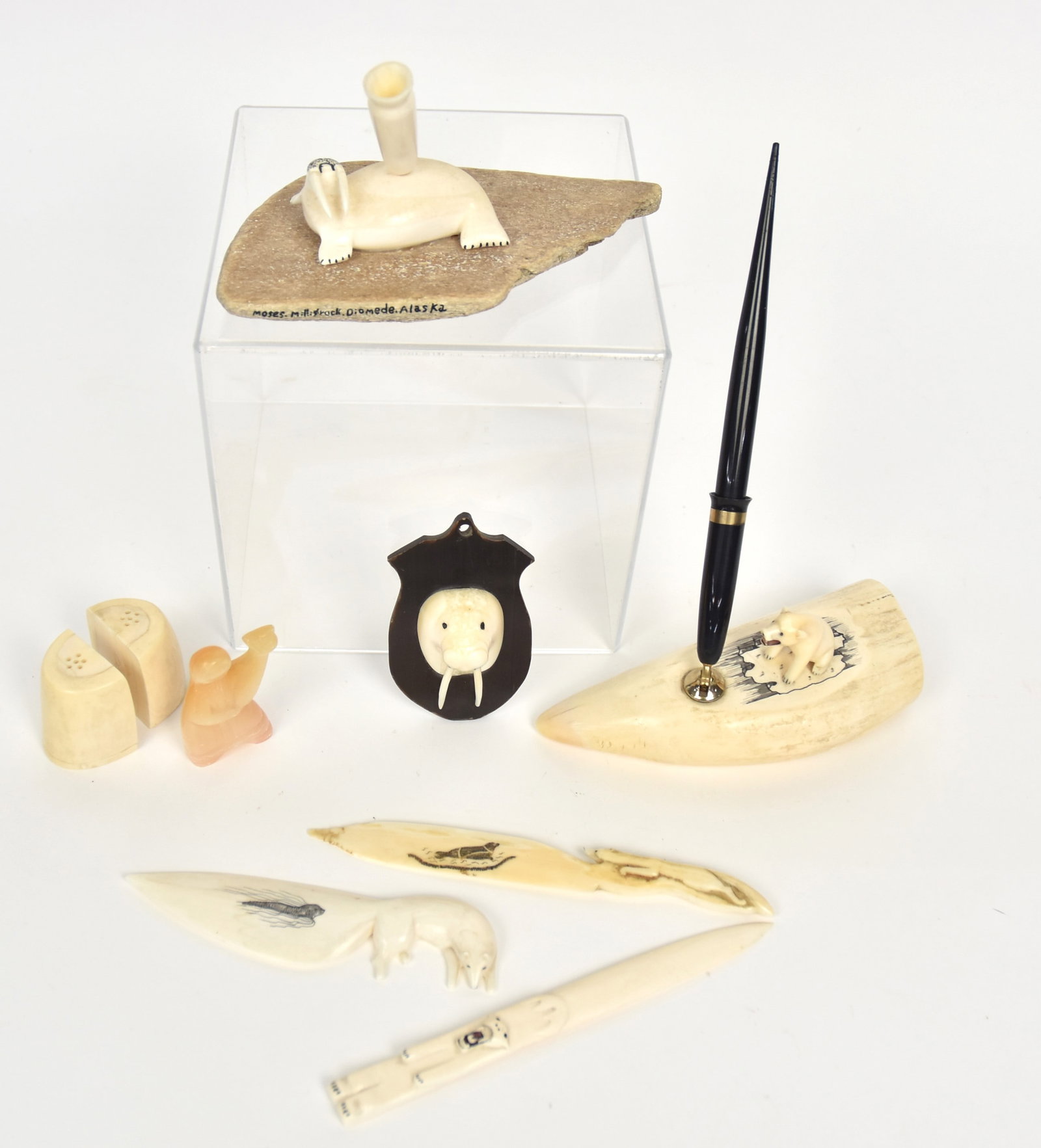 Inuit Carvings: Lot of eight, including desk set with pen made from Sperm whale tooth, with polar ear seated atop, with 14K gold tipped Sheafers fountain pen; plus 2nd desk set with carved walrus on piece of whale bo