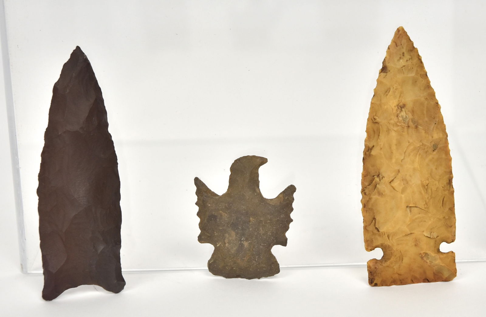Clovis Projectile Point Plus: Lot of three including a highly patinated dark brown fluted Clovis projectile point, Paleo Indian period, 3" long, not reading Dark Brown arrowhead is a St. Louis County M. Beaver Lake Find; plus Larg