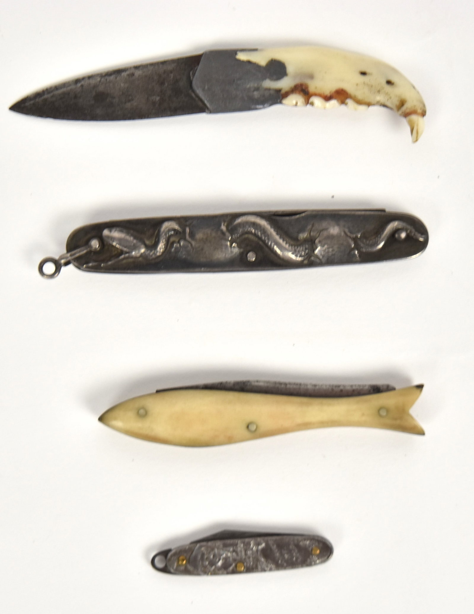 Early Pocket Knives Plus: Lot of four, including a penknife marked IXL Wostenholm Sheffield two bladed knife with sterling grips with chased rattlesnake, 6"both blades open x 3 1/4" closed; plus pen knife circa 1910 with stamp