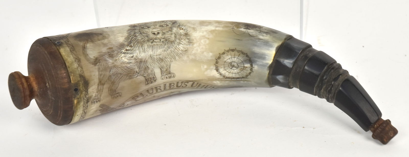 Patriotic Scrimshaw Powder Horn: Probably contemporary, with U.S. shiel breasted eagle and ion with ribbon banner reading E. Pluribus Unum, nicely carved spout and turned wood plug, 10 1/2" long. Condition Fine.