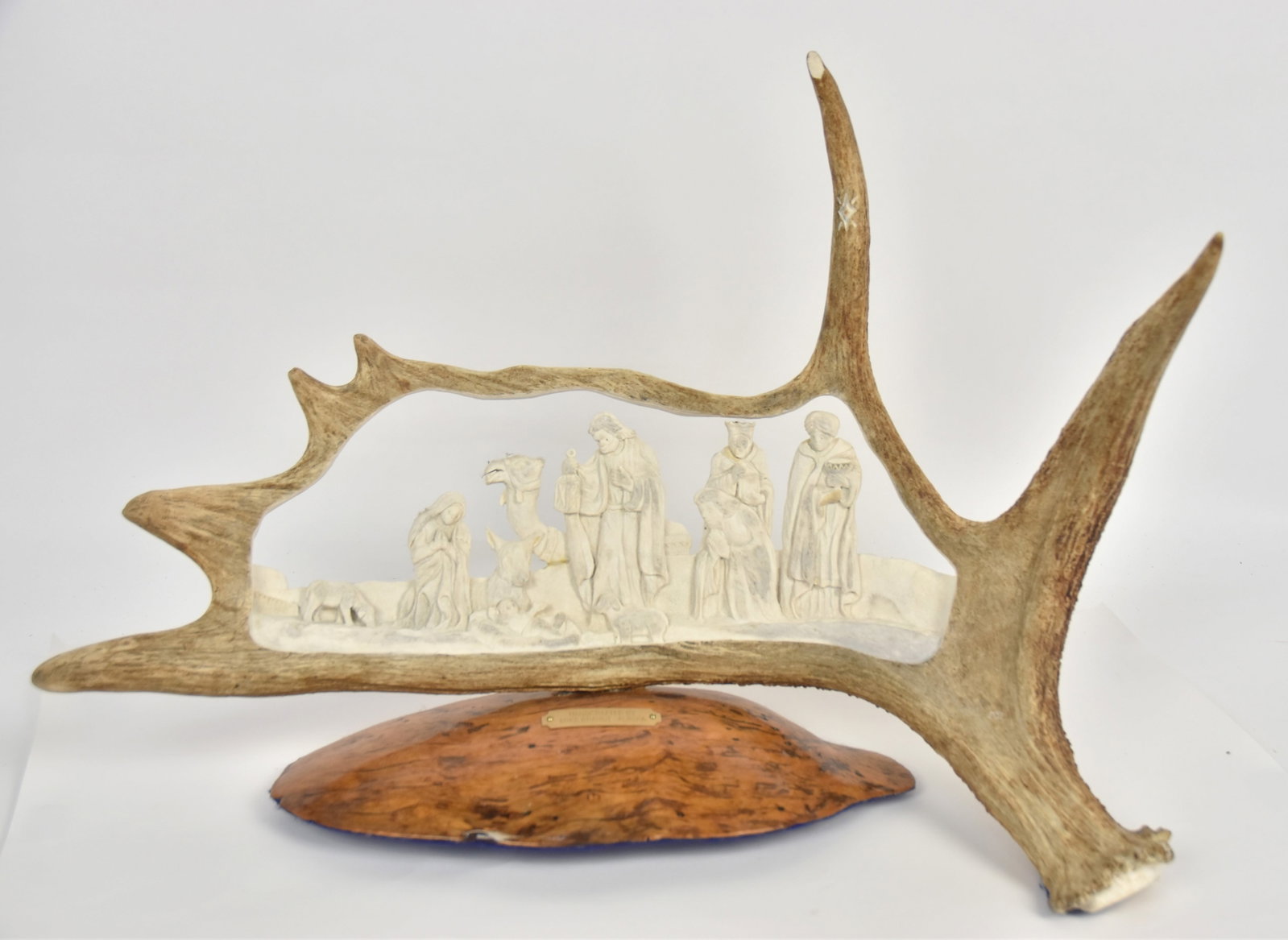 Mike Brandt Moose Antler Sculpture: Cut-out and carved antler with Nativity scene, mounted on original drift wood base with brass escutcheon reading: Handcrafted By/Mike Brandt Alaska, 27 x 96 x 18 1/2" high. Condition Fine.