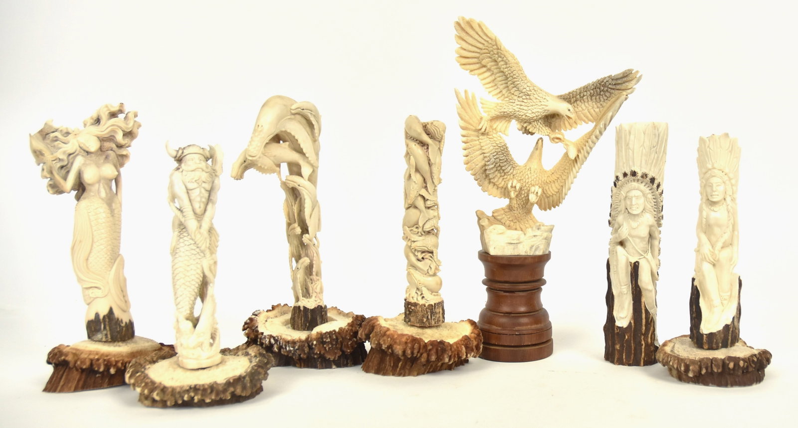 Beautiful Carved Antler Figures: Lot of seven, including two towers of baleen whales, 7 & 7 1/2" high, two eagles fighting over fish in flight on rosewood plinth, 9 3/4" high, two Plains Native Americans with full feather headdresses