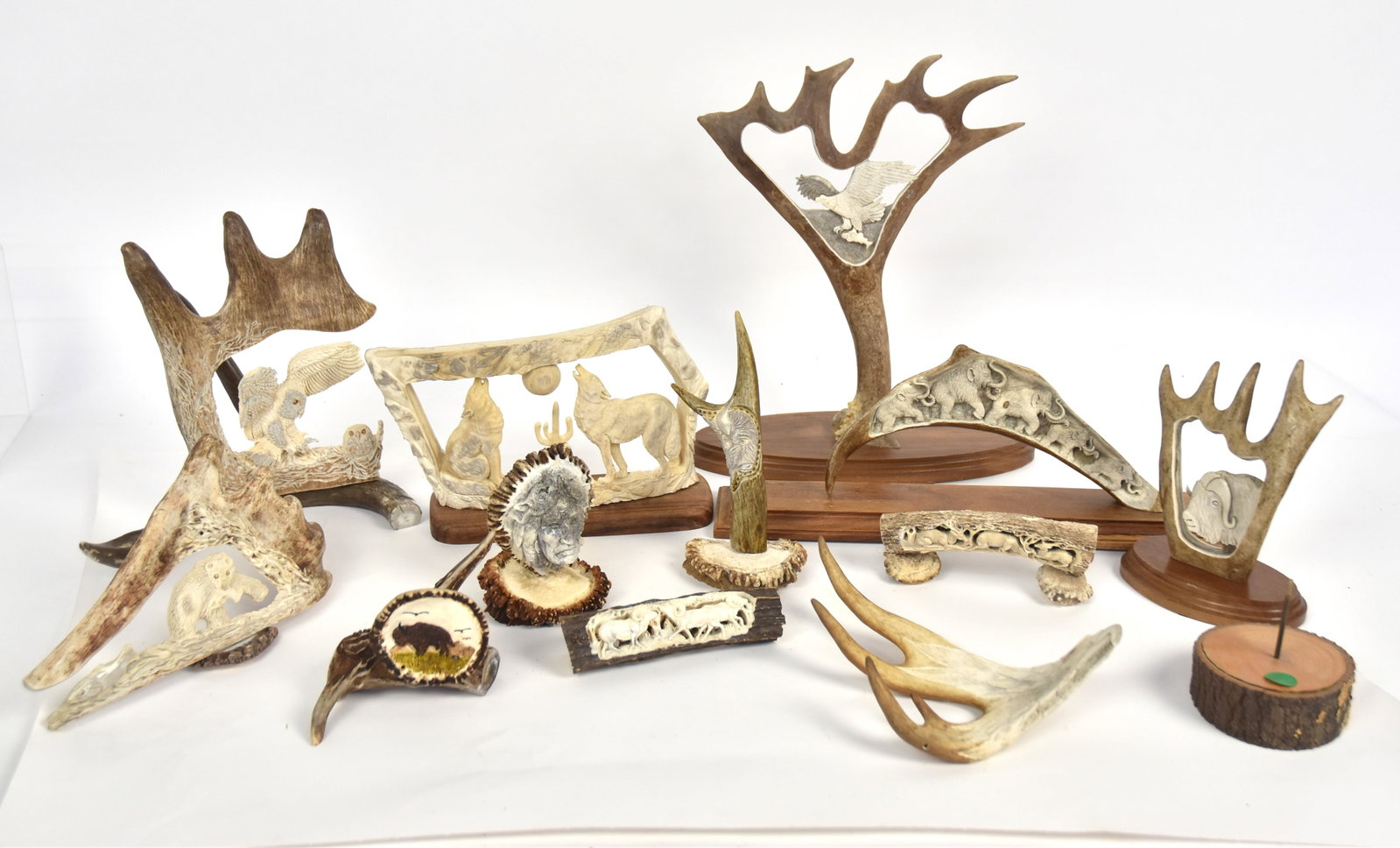 Large Lot of Antler Sculptures: Lot of 12, including two signed Tom Cooper, Alaska, one with cut-out and relief carved eagle with fish in flight on mahogany base, 11 1/2 x 4 x13 1/2" high; 2nd carved & cut-out musk ox head, mounted 