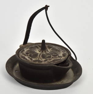 Cast Iron Betty Lamp: Stylized floral cast lid with drip grease pan surround and hanging hook, nice brown patina, 5 1/4 x 4 1/2 x 4 5/8" high with 4" hanging hook. Condition Fine.