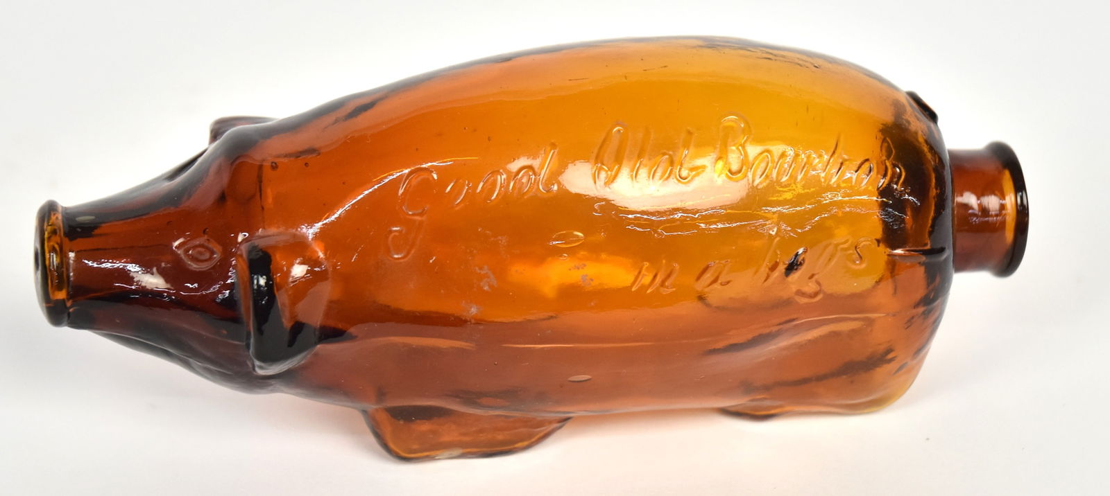 Amber Good Old Bourbon Hog Flask: Standing hog with neck at rear and embossed text on left side reading: Good Old Bourbon/in a hogs-; line pointingtowards neck, if you get the joke, 6 1/2 x 2 x 2 1/4" hgh. Condition Fine.