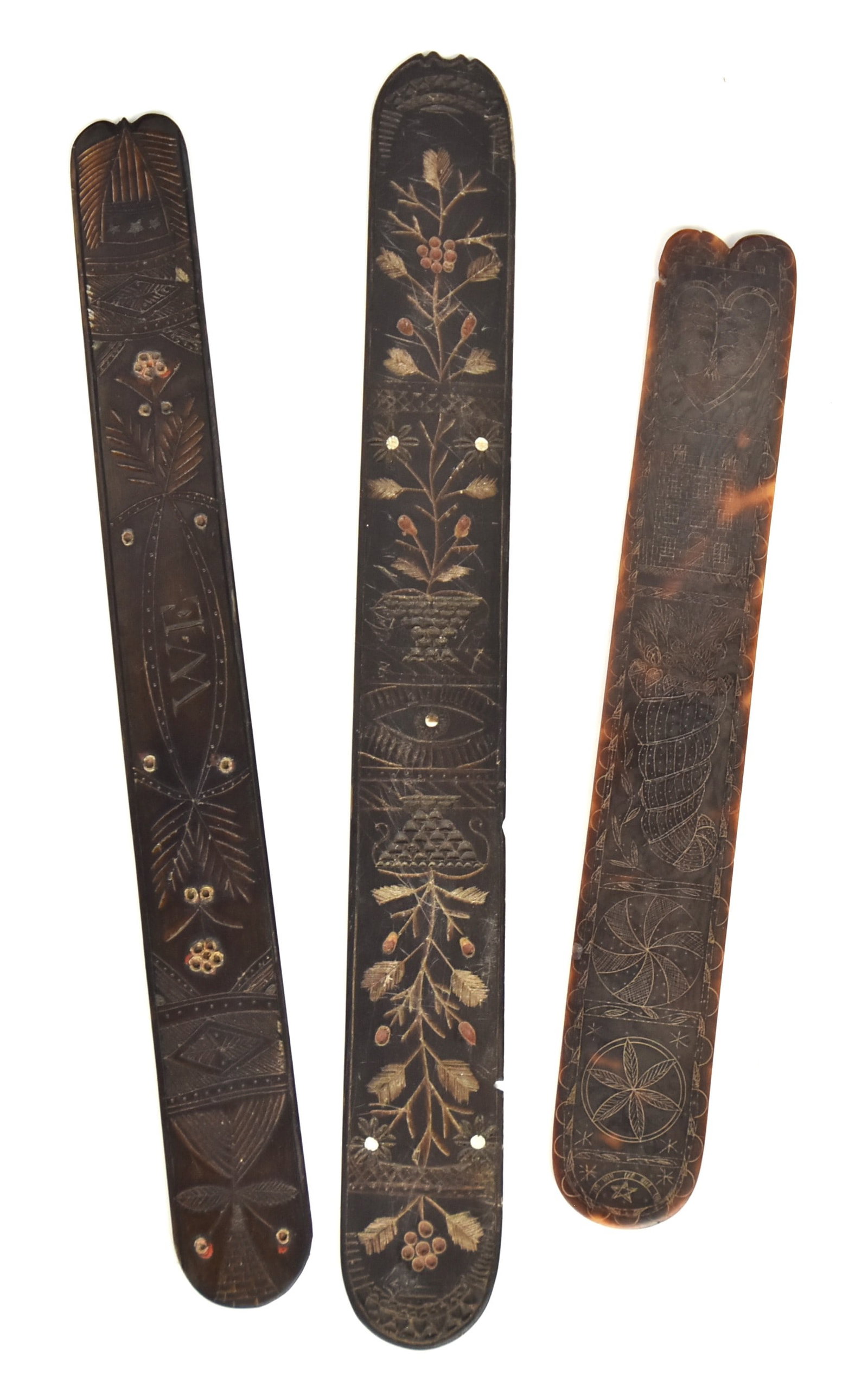 Three Scrimshaw Baleen Corset Stays: Also called busks, two with scrimshaw engraving on each face one of which has polychrome paint and baskets with flowering plants, Masonic all seeing eye on one side and anchor and initials SR with geo