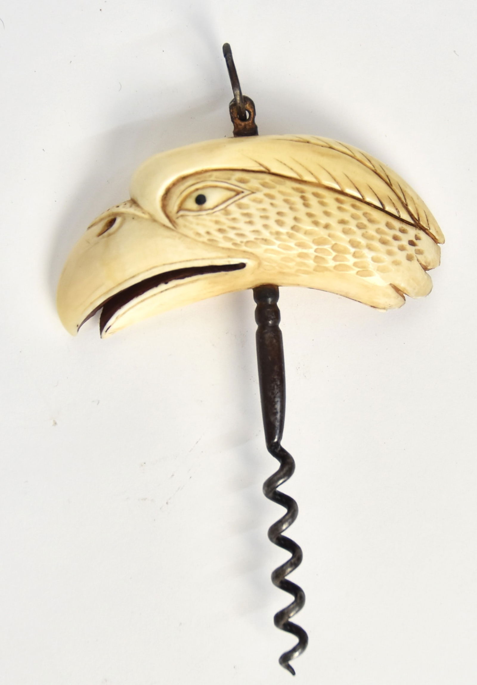 Scrimshaw Cork Screw: Whales tooth and wrought iron, grip carved in form of eagle head on whale tooth with baleen inlaid eyes and red painted interior of beak with wrought iron screw with ring handle mounted through grip,