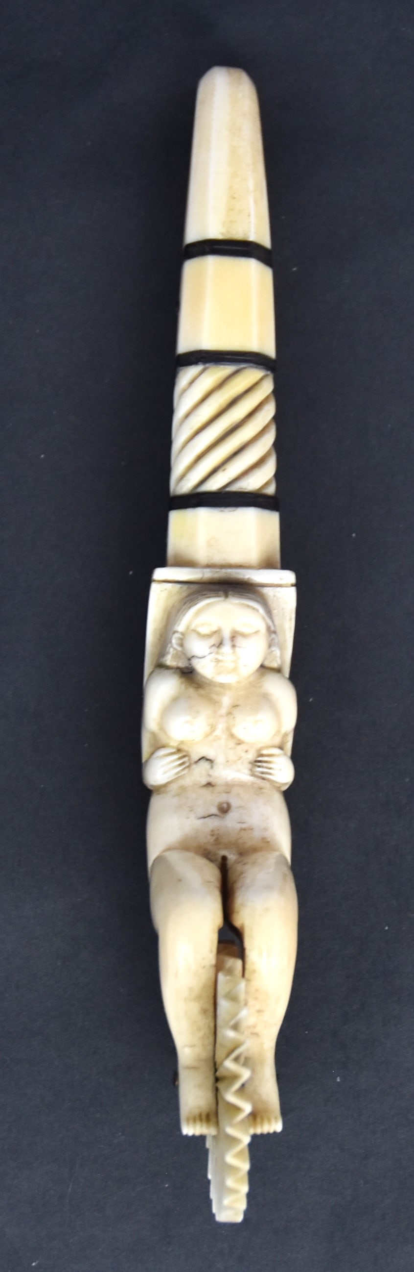 Erotic Scrimshaw Jagging Wheel: Pie Crimper in whale toot and baleen with fluting wheel held between the legs of nude lady, grip with bands and dots of baleen, nice old patina, 7 34" long. Condition Fine.