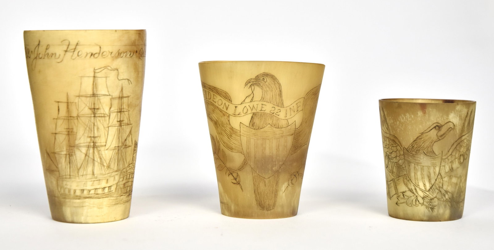 Three Scrimshaw Horn Cups: Including two with U.S. shield breasted spread winged eagles, smaller with crossed cannon, reverse with inscription reading: Sargn/J.H. Bradford 3 Arty/1813 (American War of 1812) nice patina, 1 1/8" 