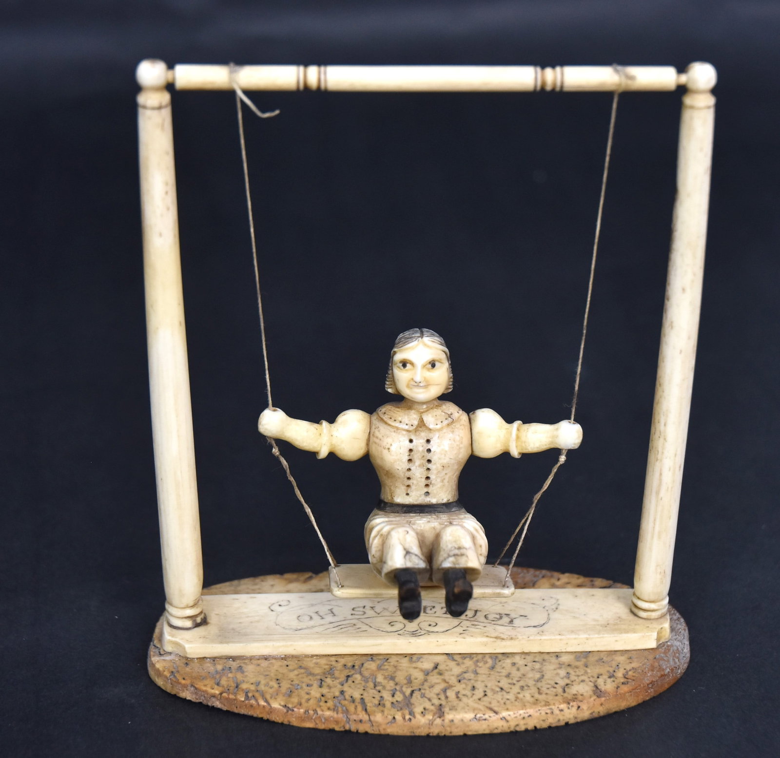 Hidden Erotic Scrimshaw Carved Swinging Lady: Whale bone,walrus, baleen & wood, entitled with engraved Oh Sweet Joy on base, figure of Victorian lady in walrus with baleen belt and carved wood shoes, seated on suspended swing, mounted between two