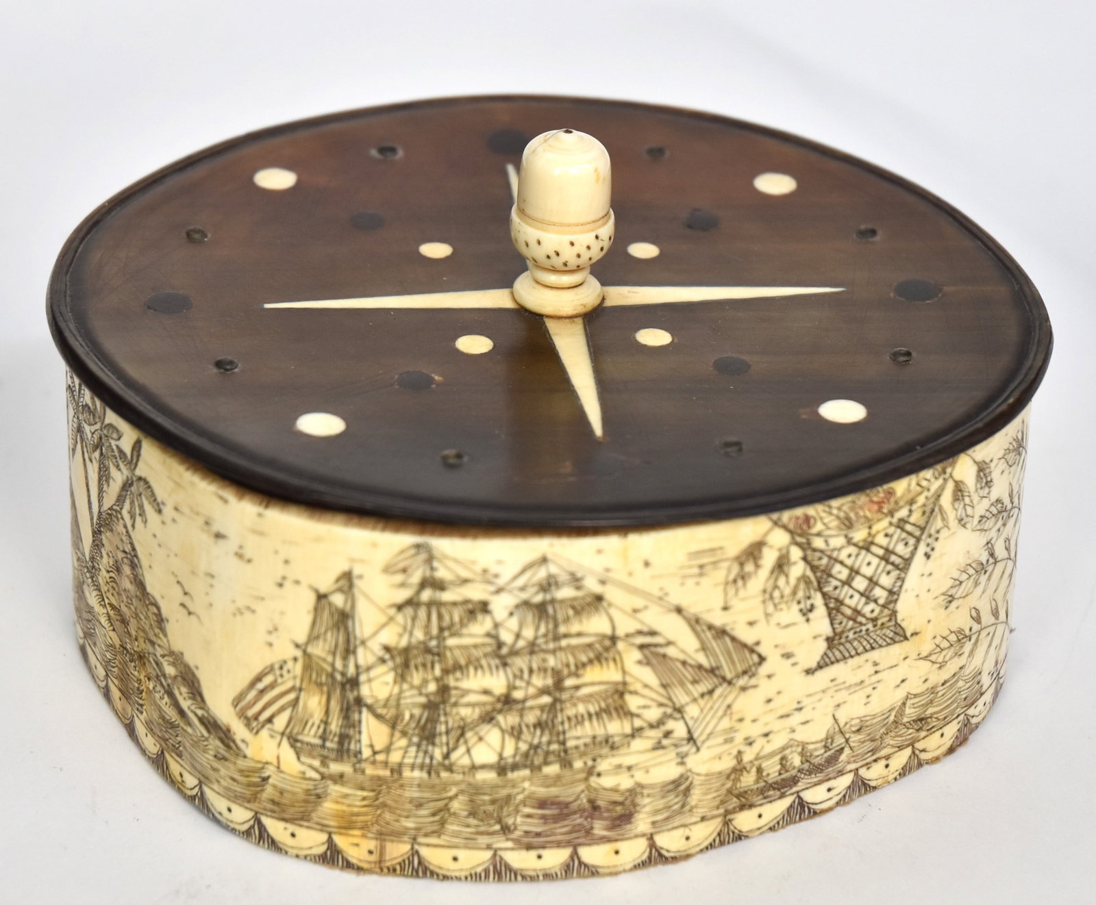 Fine Scrimshaw Ditty Box: Circular bent whale bone with engraved scene of three masted ship with U.S. flag with one whale boat out hunting one whale with island with palm to left, right basket of flowers and tree; reverse with