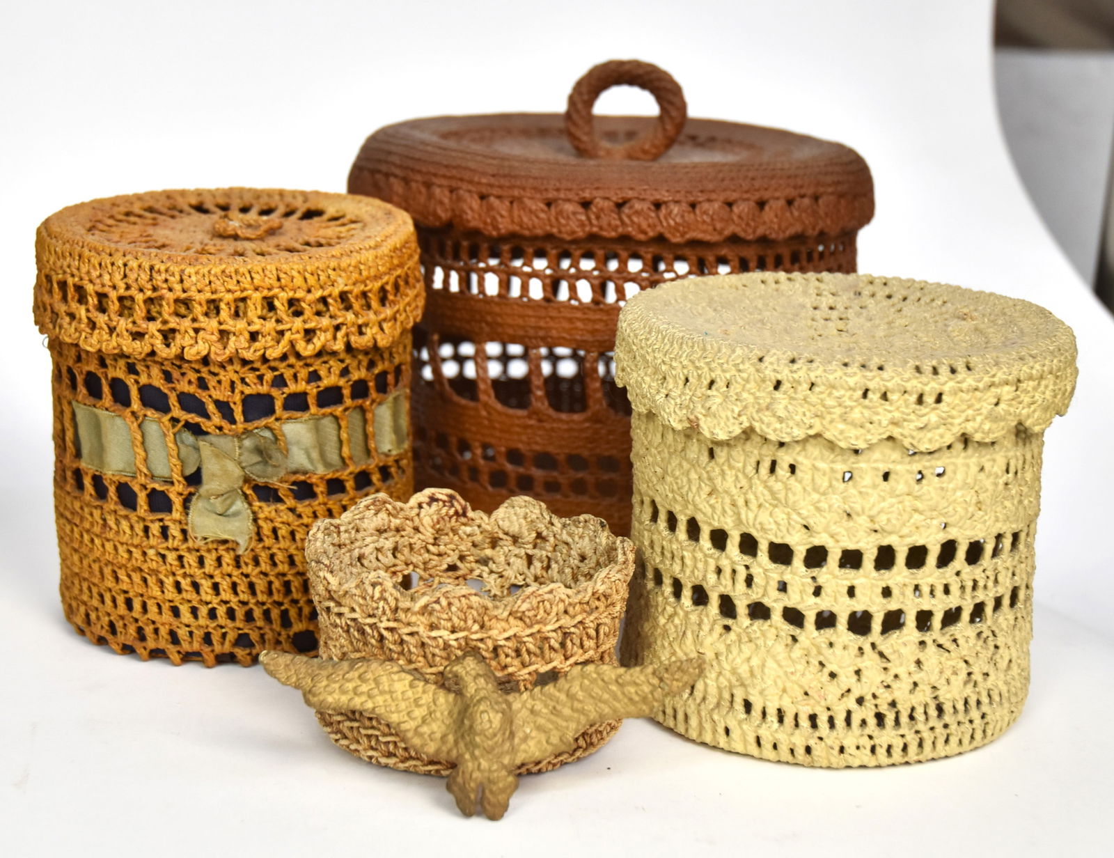 Sailors Knot Work Baskets Plus: Lot of five all with open work sides, including largest in original brown painted finish with ring handle on lid, 7" diameter x 6 1/2" high; plus 2nd in white painted finish, 5" diameter x 4 1/2" high