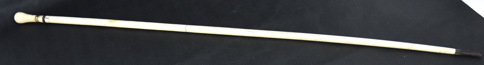 Fine Scrimshaw Walking Stick/Cane: Whale bone, horn & walrus with 2" turned walrus knob over four rings of horn and walrus on tapered whale bone shaft, with 1 1/2" horn ferrule, total length 35 1/4"