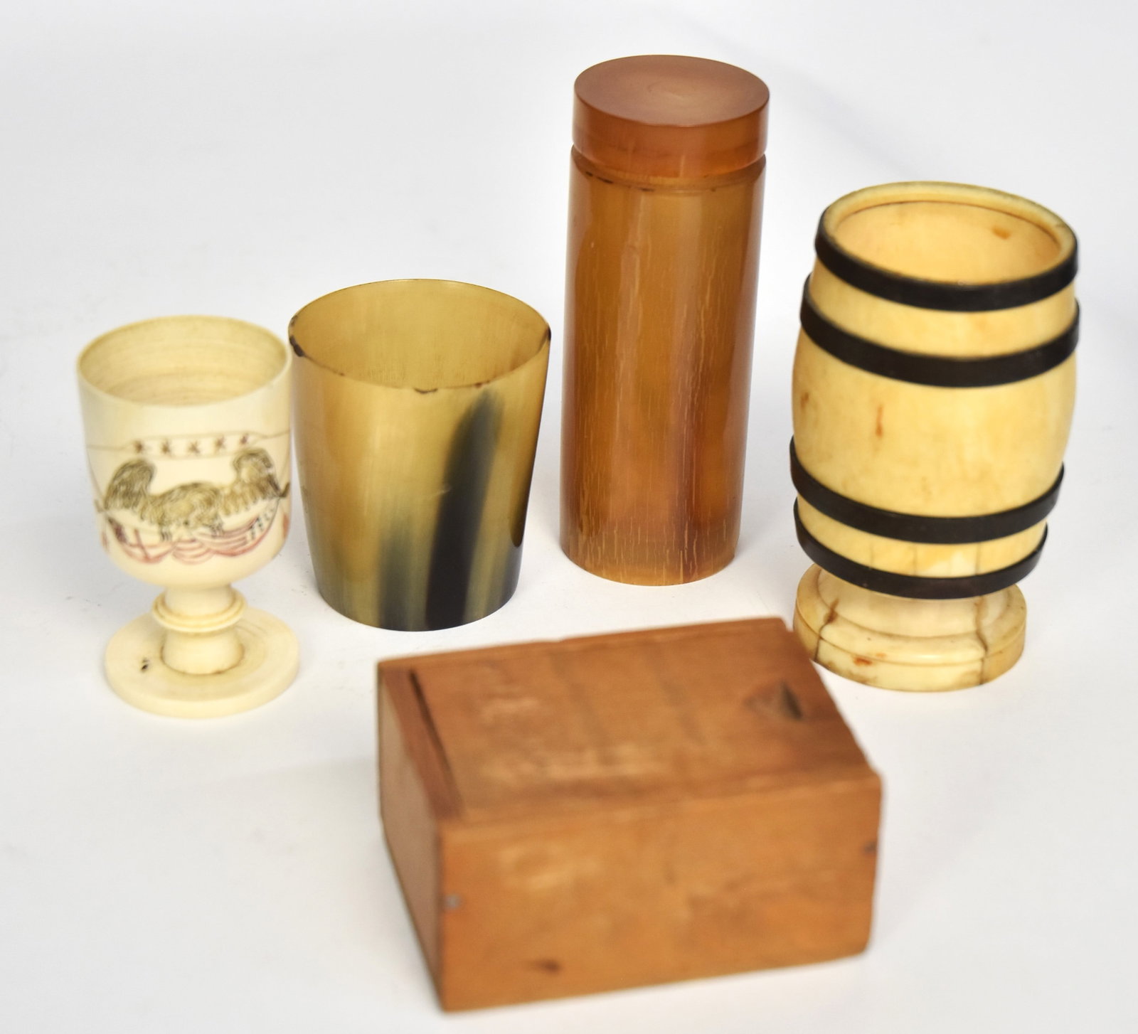 Group of Scrimshaw Games: Lot of five, including turned whales tooth footed cup with four baleen bands and two pair of bone dice, 1 3/4" diameter x 3 1.8" high; plus turned whale tooth footed cup with engraved spread winged ea