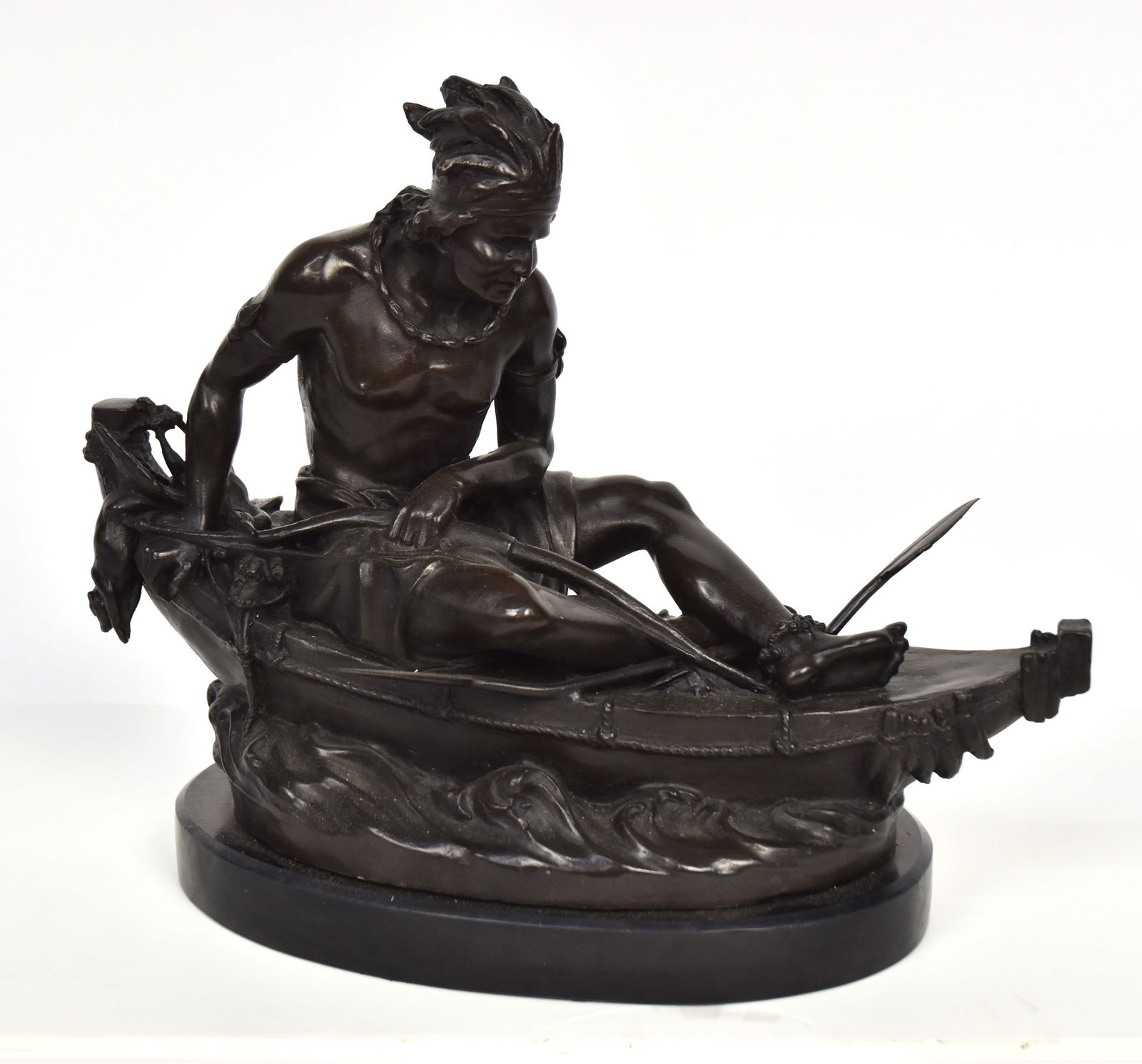 Duchoiselle Native American Bronze: Native American man in canoe with bow and quiver of arrows paddle and dead duck, signed on right rear of canoe, mounted on black slate base, 15 x6 x 12". Little is known of this French sculpture, not