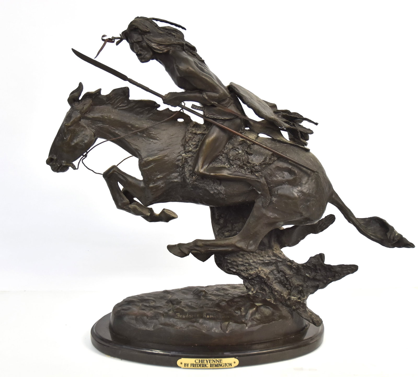 Fredrick Remington Cheyenne Warrior Bronze: Mounted Plains Cheyenne Native American warrior/hunter with lance and shield, signed Frederick Remington on base and mounted on black slate base, late 20th century casting, 14 1/2 x 8 x 19 1/2" high. 