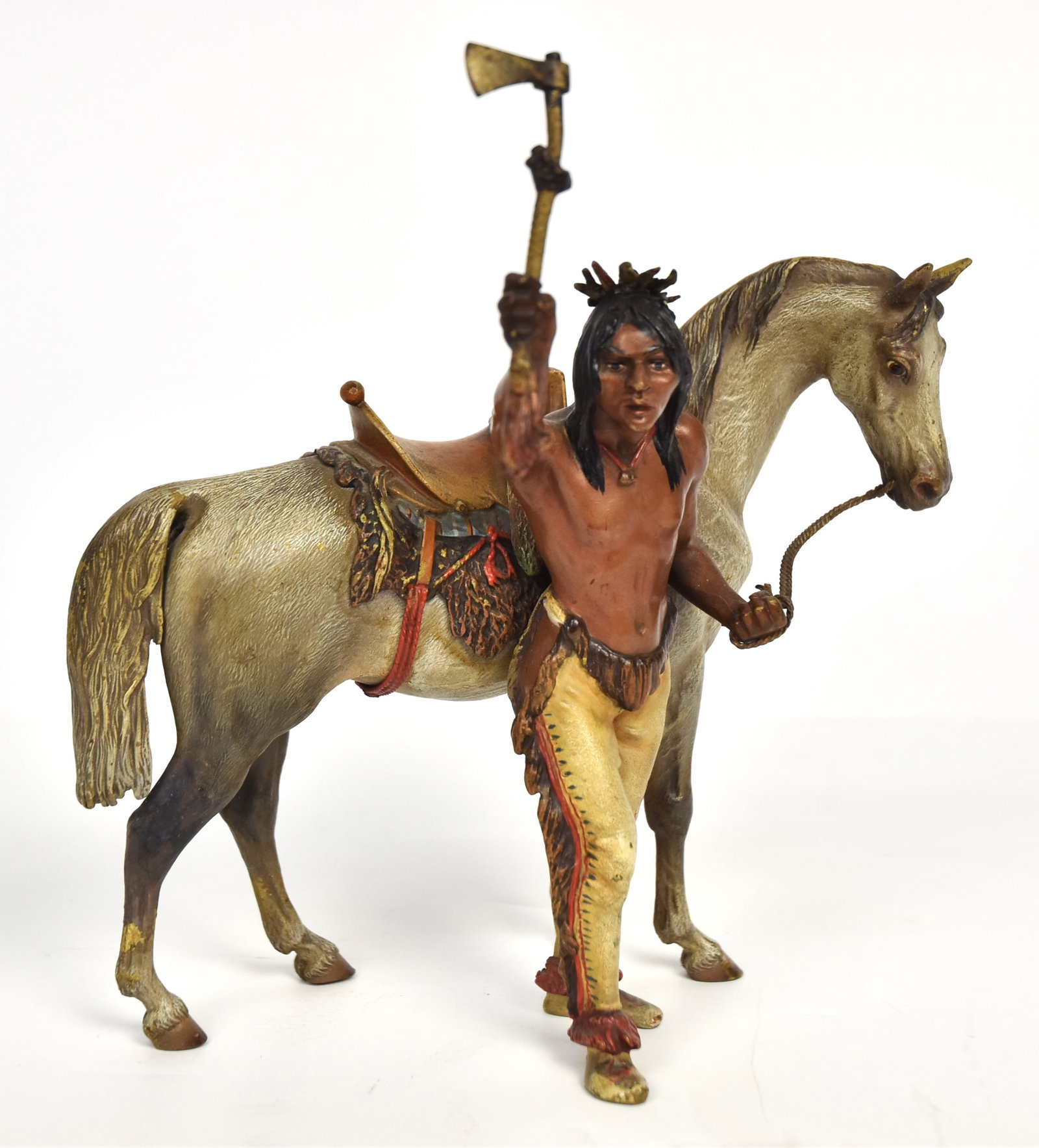 Franz Bergman Native American Cold Painted Bronze: Austrian depicted a Plains Native American in buckskin leggings and holding tomahawk in right hand and reins of horses bridle in left,marked on underside of horse with amphora B mark Geschutzt 3605, 4