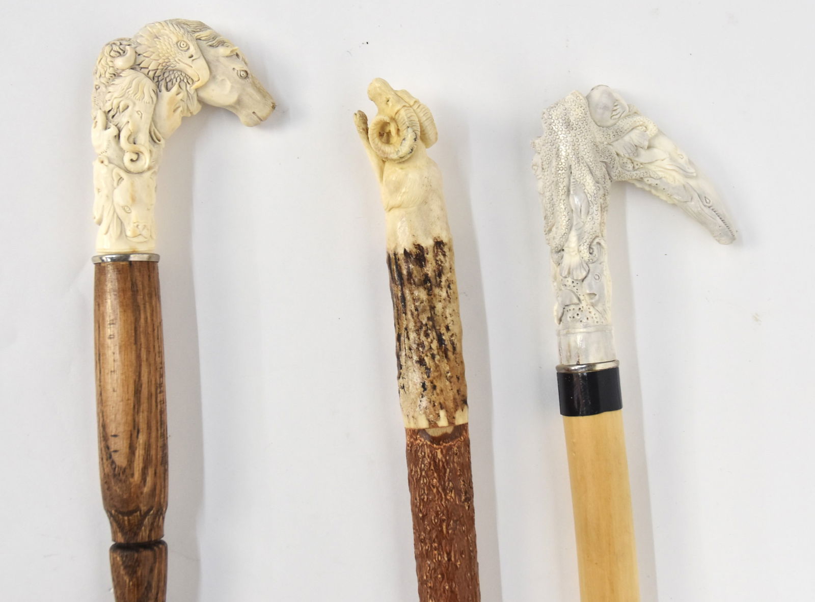 Three Carved Antler Handled Canes: Including one with half charging mountain sheep, mounted on wood shaft with copper & rubber ferrule, total length 37 1/2" and two with crook handles carved with many creatures; 1st with sea life inclu