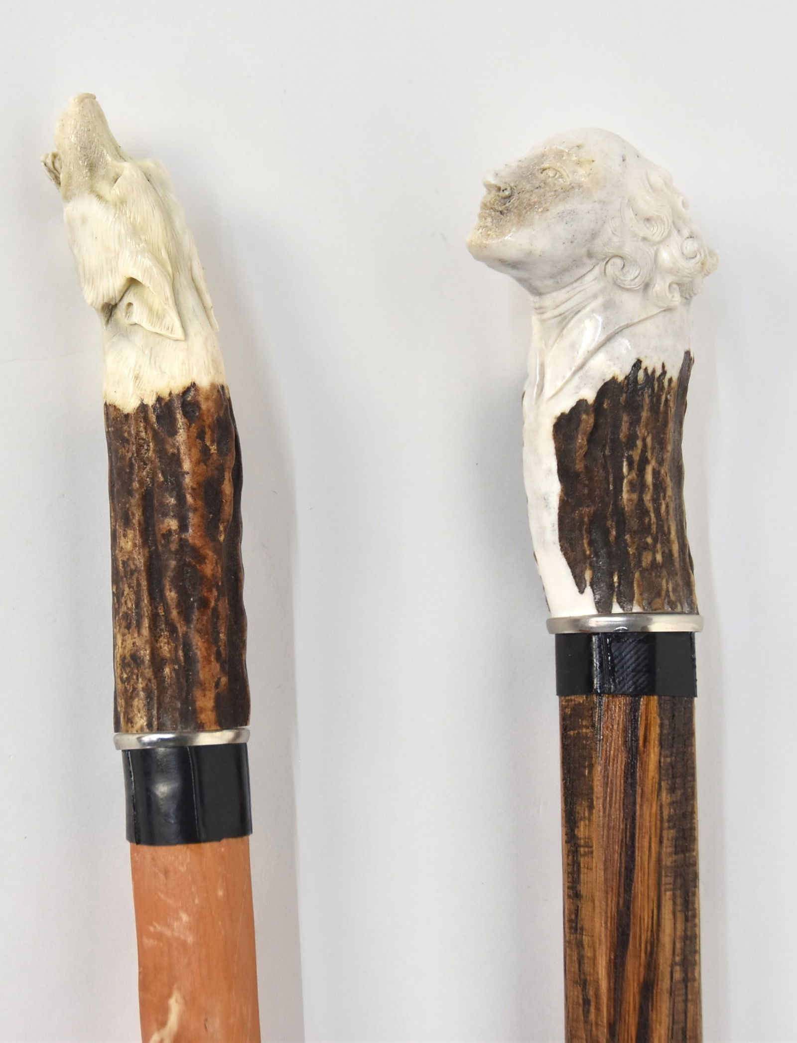 Two Carved Antler Handled Canes: One with carved wolf head, artist monogram and dated 2015, on tapered hardwood shaft with branch stubs and rubber ferrule, total length 36 1/4"; and one with ladies head grip, mounted on turned & tape