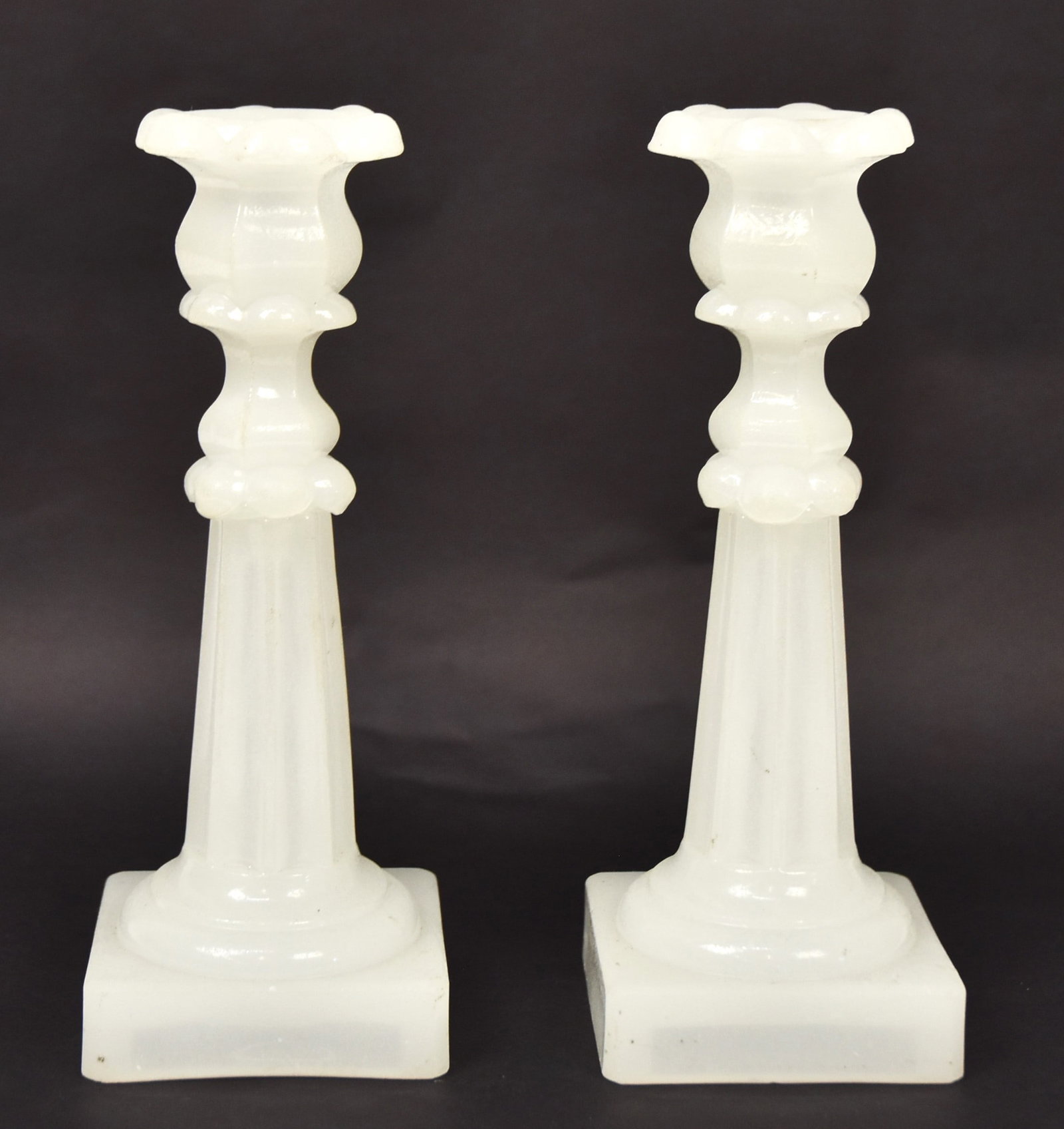 Pair Sandwich Glass Candlesticks: Clambroth with flower pedal form sockets, stop fluted tapered columns, and square base, 3 3/8" square x 9" high. Condition Fine.