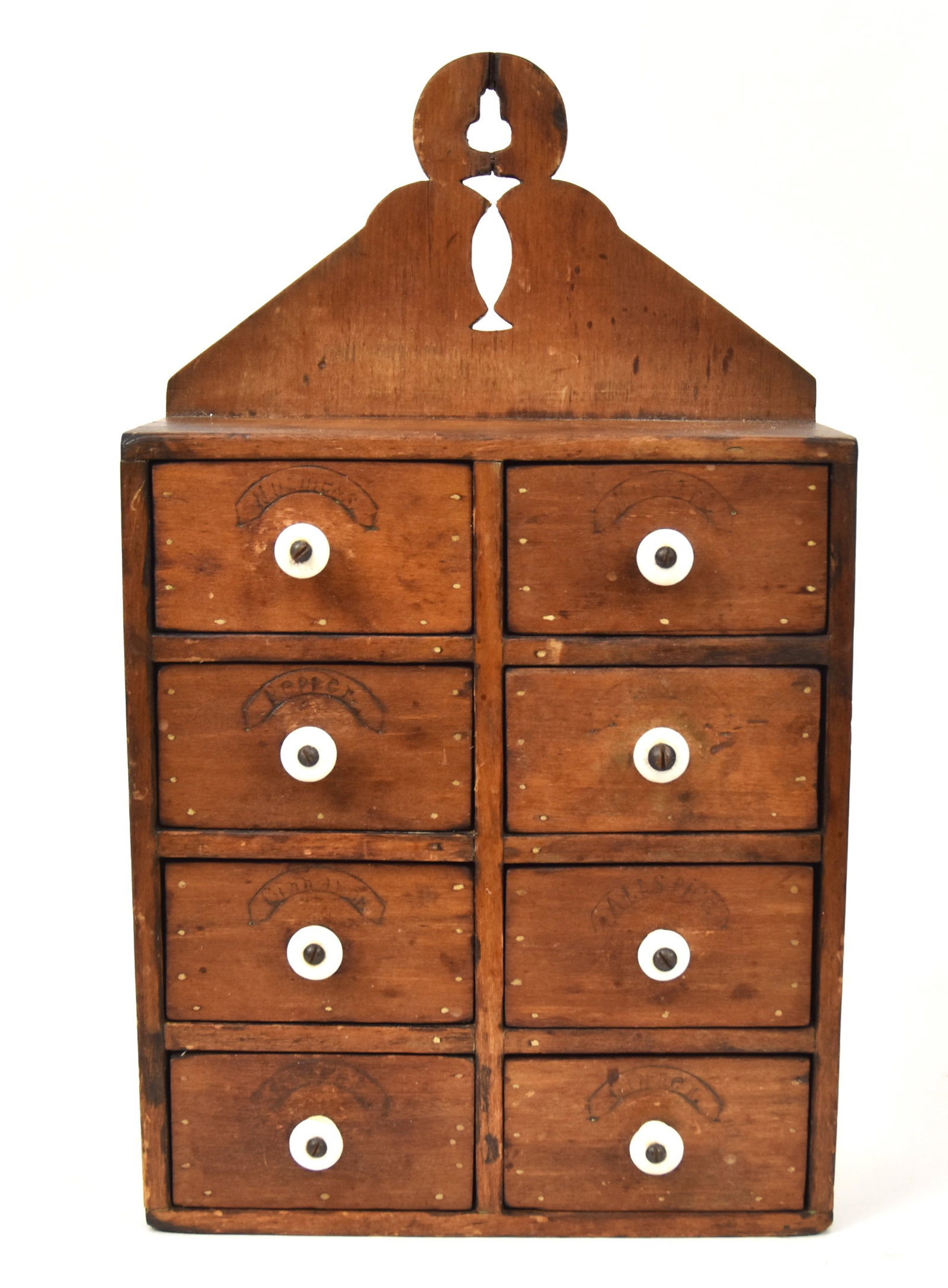 Early Hanging Spice Cabinet: Maple with scroll cut-out crest two columns of four drawers with stamped spice names and original porcelain knob handles, nice old patina, 8 3/4 x 4 x 15" high. Condition VG+.