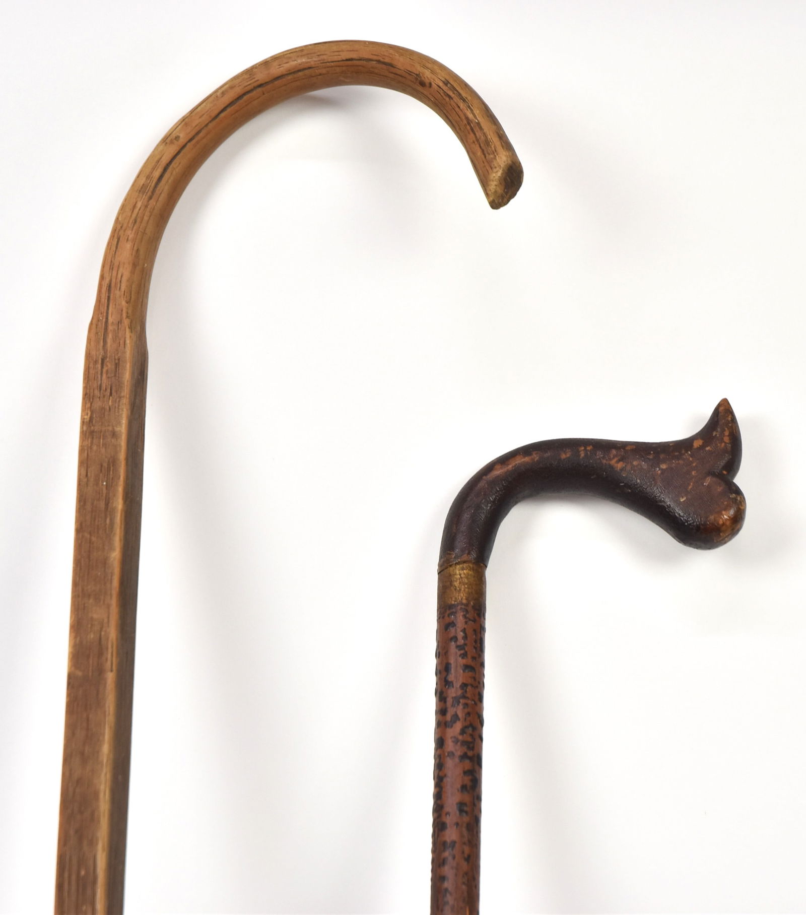 Two Old Canes: One bent hickory shepherds crook branded French Lick Ind, 37 12" long; and carved crook handled cane in original painted alligatored finish, total length 33". Condition 1st with split in lower shaft,