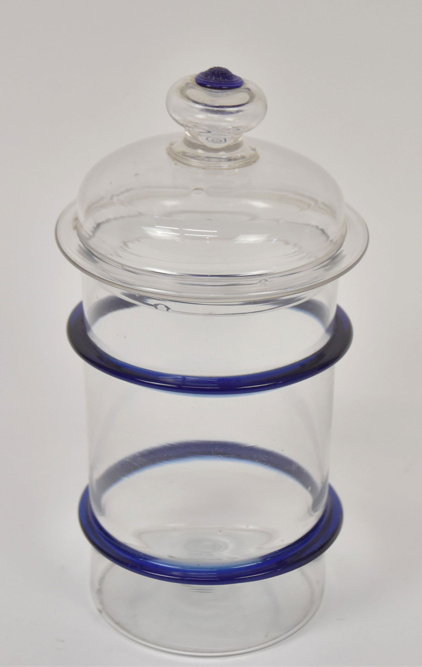Cobalt & Clear Glass Store Canisters: Hand blown with domed lid with air-trap knob finial with cobalt prunus berry atop, base with two cobalt applied rings, snap pontil on base, 5 3/4" diameter x 11" high. Condition tiny flake on the unde