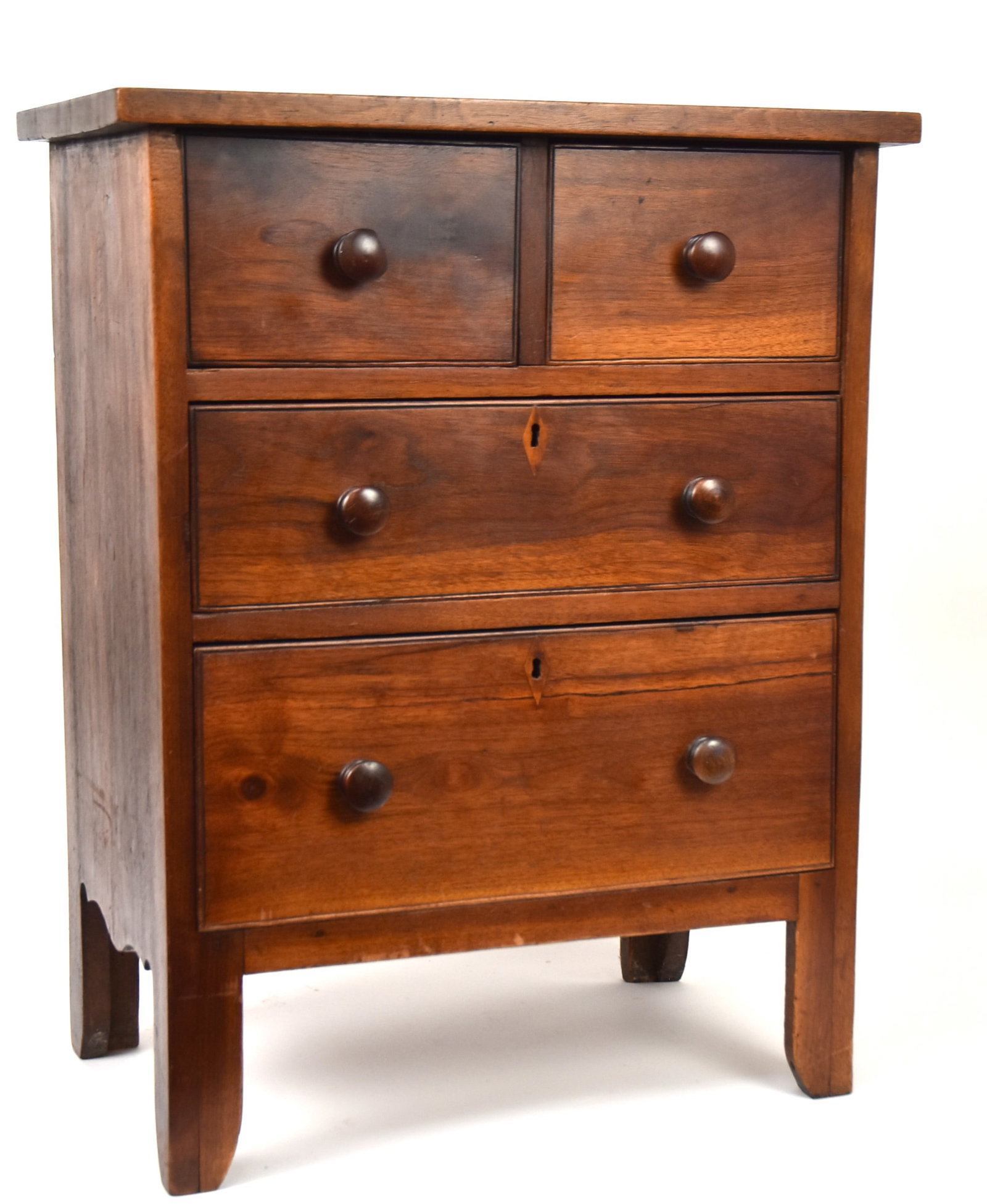 Kentucky Hepplewhite Miniature Chest: Walnut, circa 1820 with overhanging top over two divetailed drawers, over two graduated dovetailed drawers, all with scribed cock beaded edges, original turned walnut pulls and lower two drawers with 