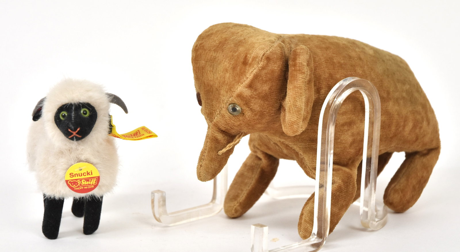 Two Stuffed Toys: Including a early mohair, excelsior stuffed standing elephant with glass eyes and thread sewn tusks, 8 x 3 x 5" high; and newer Steiff ram with green glass eyes, felt horns, tin button, silk tag and p