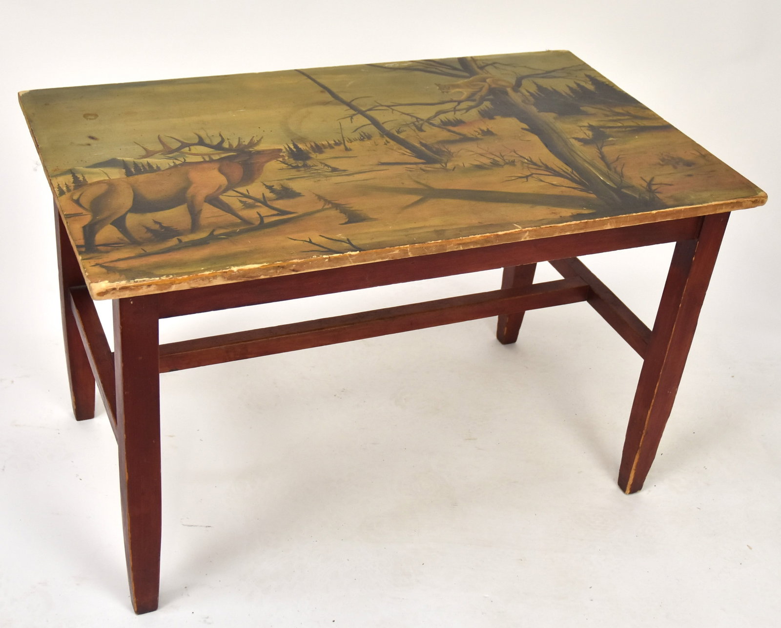 Folk Art Painted Hunting Lodge Table: Birch with polychrome painted top with elk bellowing at a treed mountain lion in mountain landscape, red painted tapered legs with H stretcher, circa 1930s, with glass top, 18 x 30 x 18 1/2" high. Con