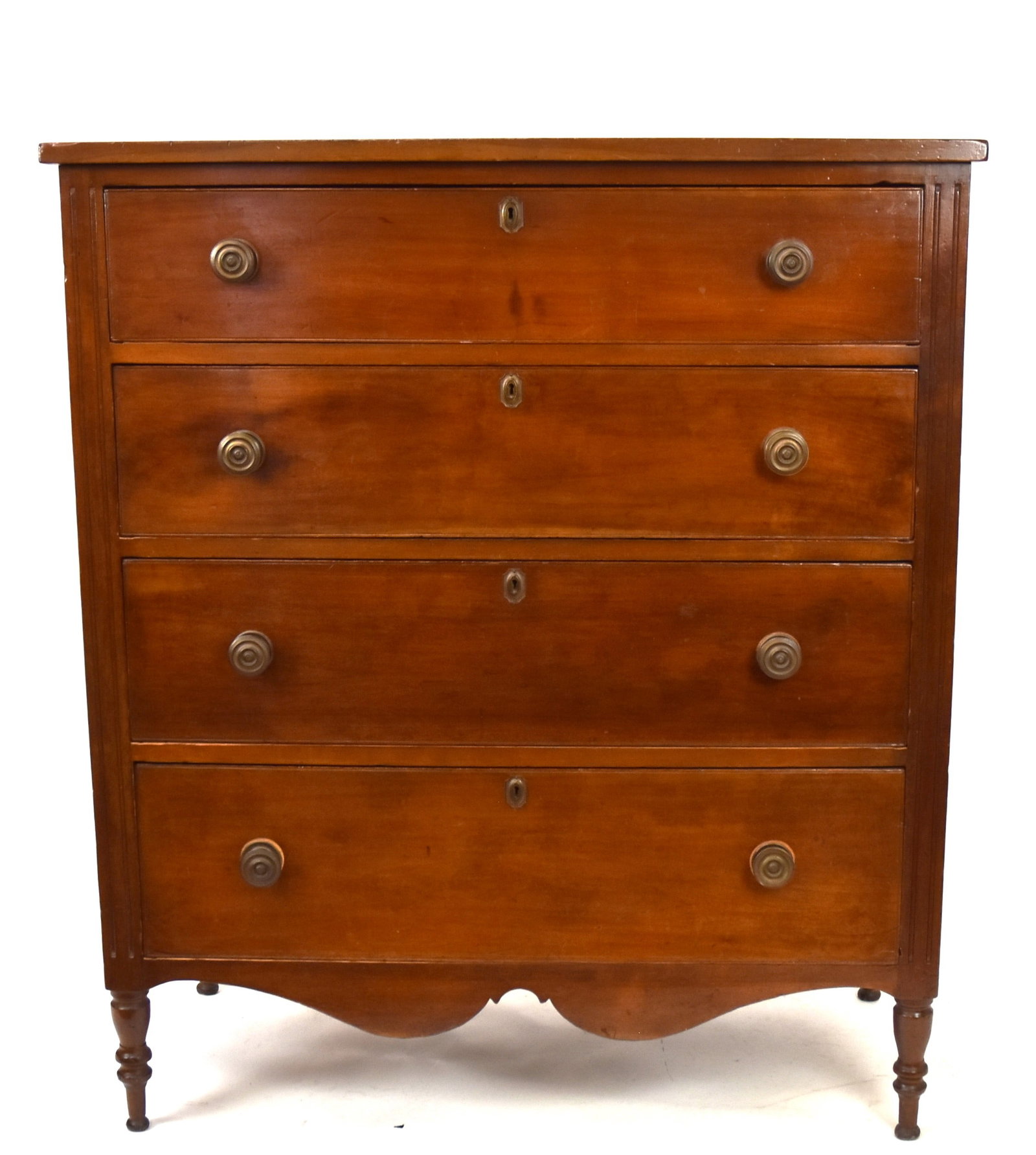 Kentucky Cherry Sheraton Chest: Overhanging top, over four graduated dovetailed drawers with Federal brass knobs and key escutcheons, with scribed cock beded edges, front stiles with two vertical flutes, nice cut-out apron and turne