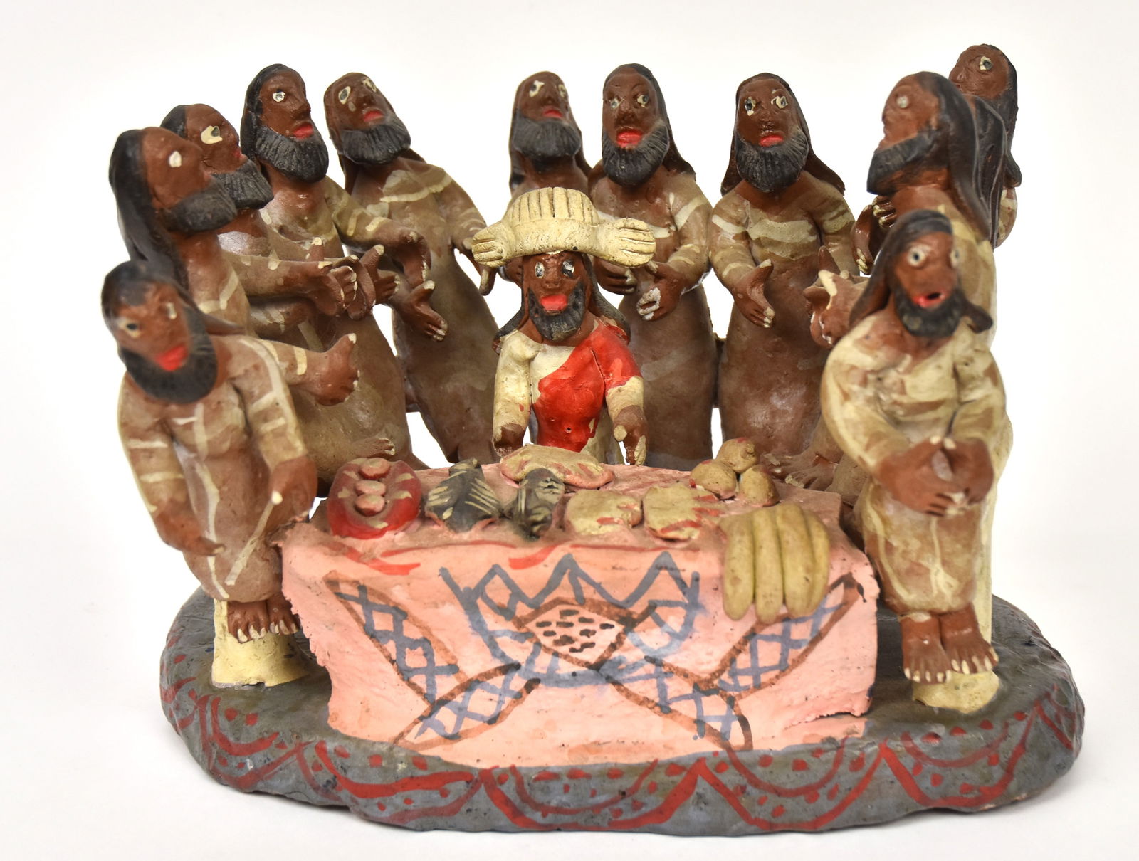 Mexican Folk Art Terra Cotta Last Supper: All hand molded with 12 apostles surrounding Jesus at table set with food, polychrome painted, 9 x 11 1/2 x 9" high. Condition couple of glued breaks, VG-.