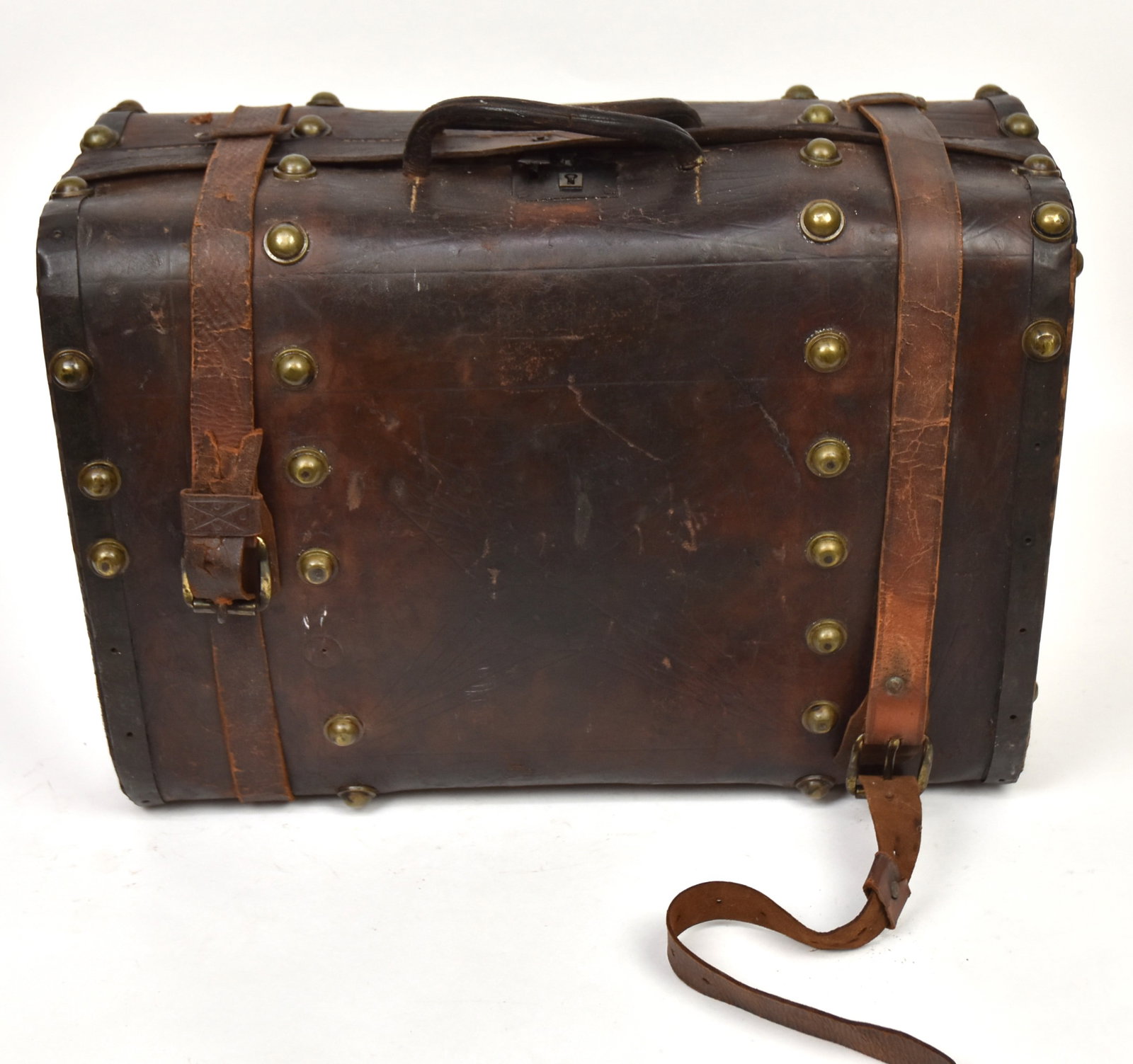 Early Leather & Brass Traveling Case: Circa 1820 with wrought brass lock with cover stamped Patent, four rows of 1" domed brass studs encircling brown cow hide covered wood case with original printed cotton fabric liner and two leather st
