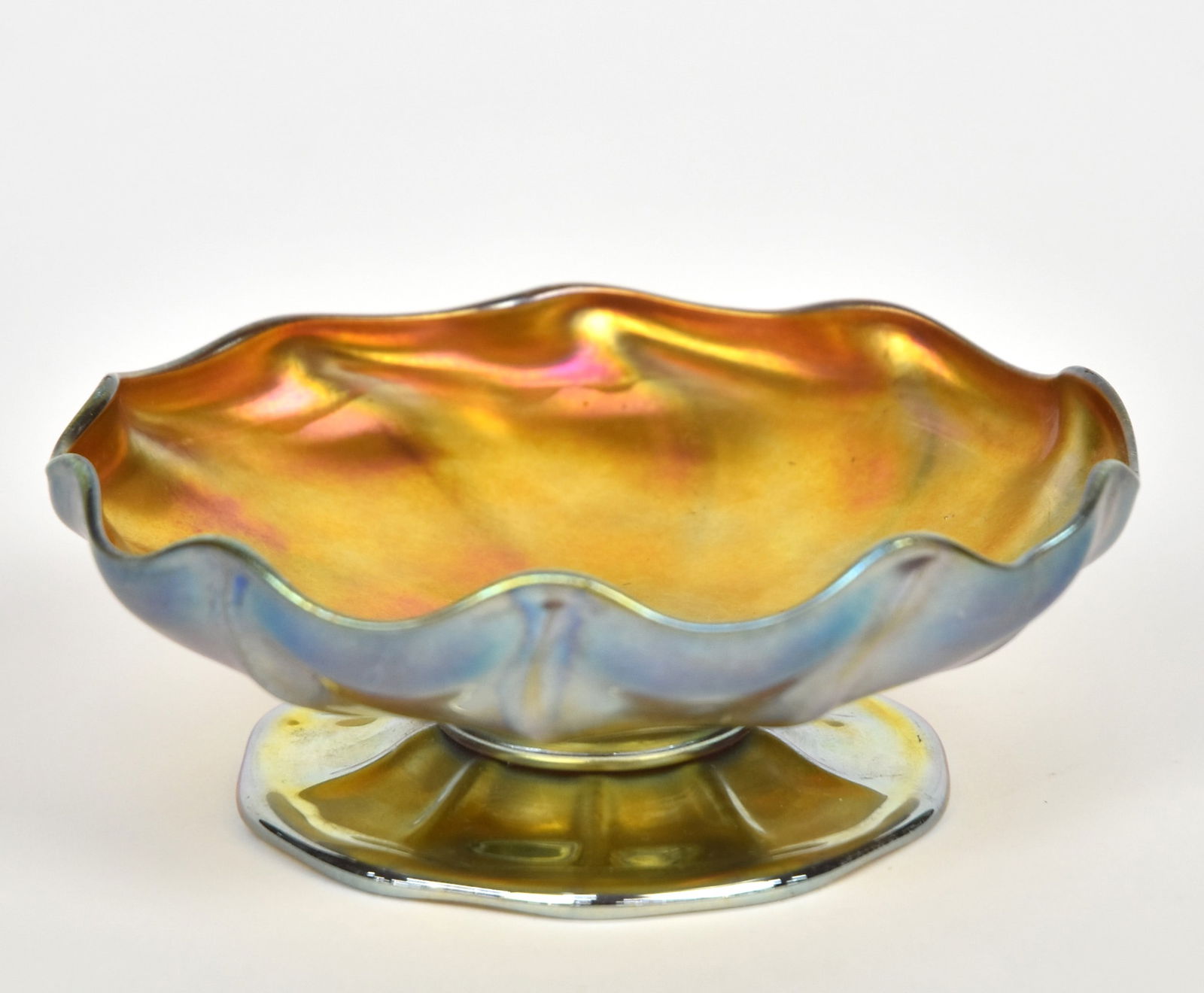 Tiffany Favrile Iridescent Gold Sweets Compote: Featuring a scalloped rim & ribbed body attached onto a ribbed base joined by a ring connector. The base edge is slightly scalloped & turned under. 2 1/4”T, 6”D. Engraved L.C.T. Favrile. M
