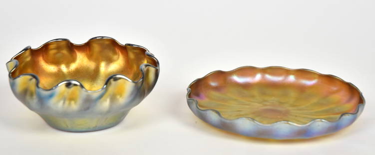 Tiffany Favrile finger bowl, Nash under-plate: Deeply scalloped & ribbed iridescent gold bowl. 2”T, 4 1/4” across. Engraved L.C.T. Favrile. Resting upon a Nash ribbed & scalloped under tray. 3/4”T, 5 1/8”D. Engraved Nash,