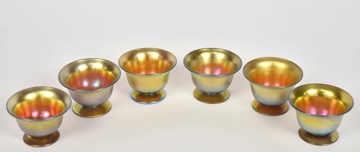 Six Steuben gold Aurene footed nut bowls: All engraved Aurene, 3067. 1 1/2”T. Magenta highlights. Awesome set! Very good condition.