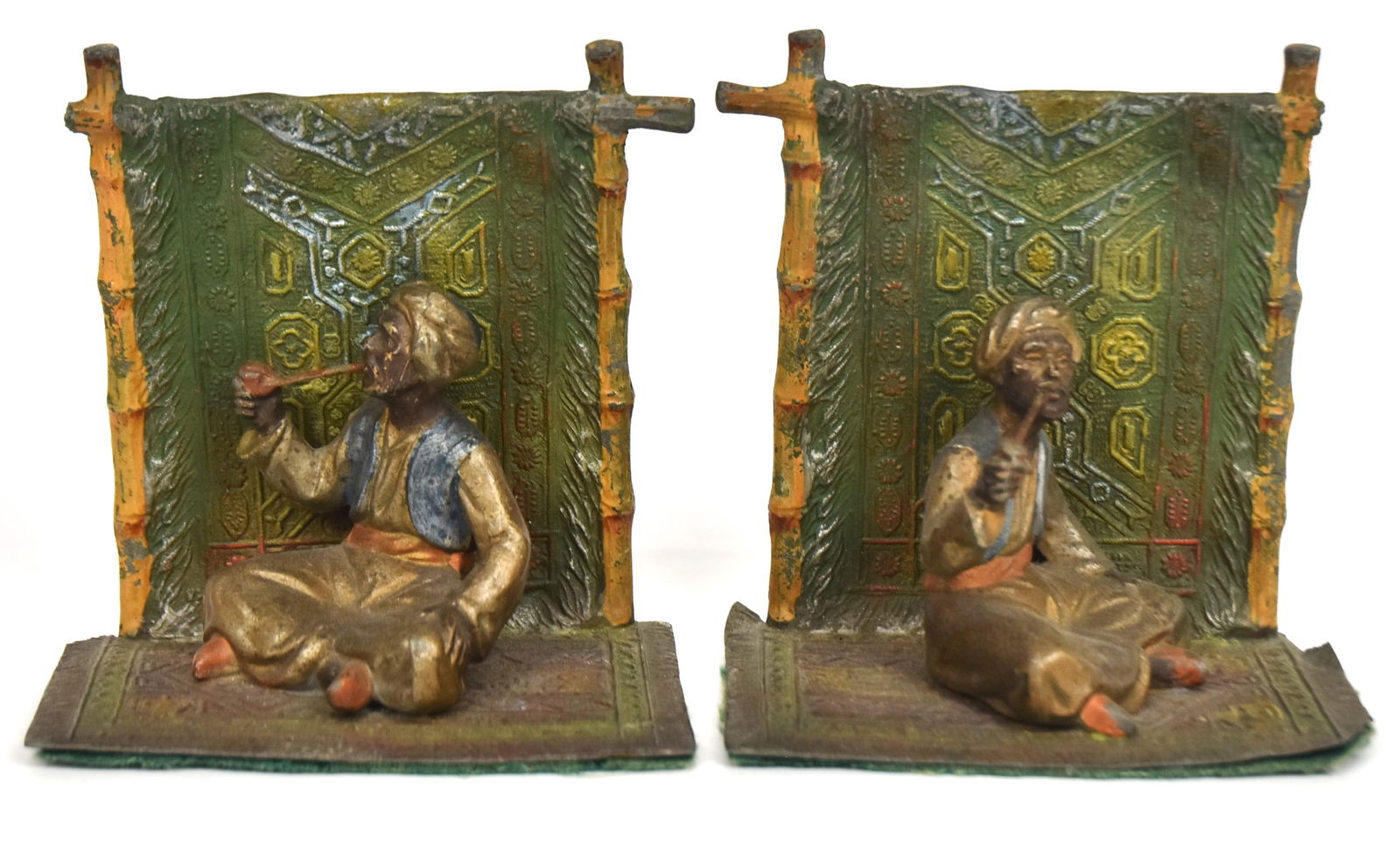 Persian Cold Painted Bookends: Of carpet seller smoking a pipe, cast white metal, 4 3/4 x 3 x 5" high. Condition paint circa 90%.