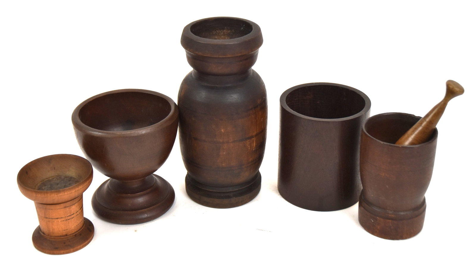 Lot of Five Early Treenware: Including small mortar and pestle 4 1/4" H. Plus jar with painted black stripes. 9" H. Plus a pedestal bowl. 4 1/2" H. Plus a cylinder jar. 4 1/2" H. Plus a sander. 3" H. All with good old patina. All