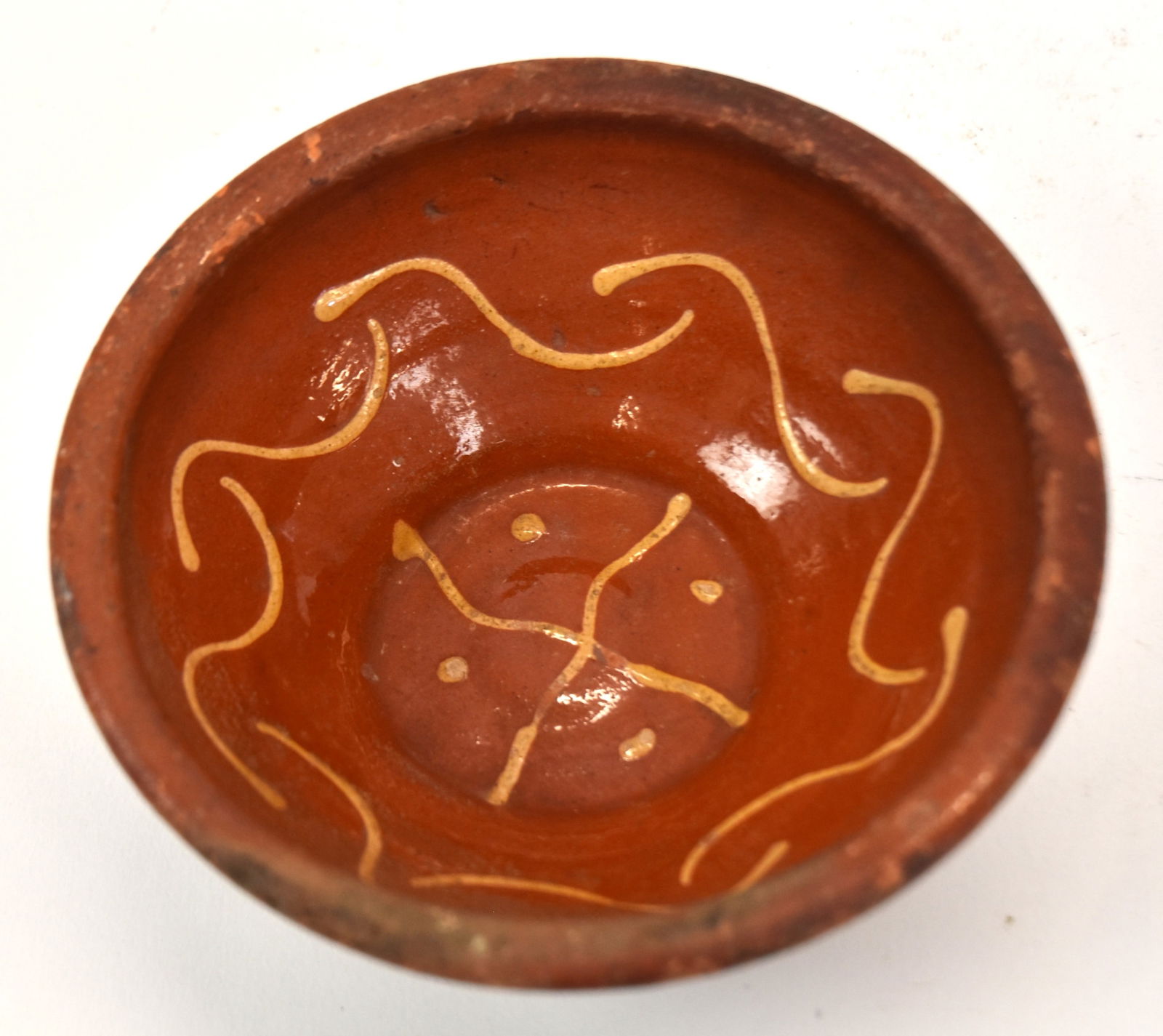 Early Redware Decorated Bowl: With dot and curved line decoration. 2 1/2" H x 6" Dia. Good condition.